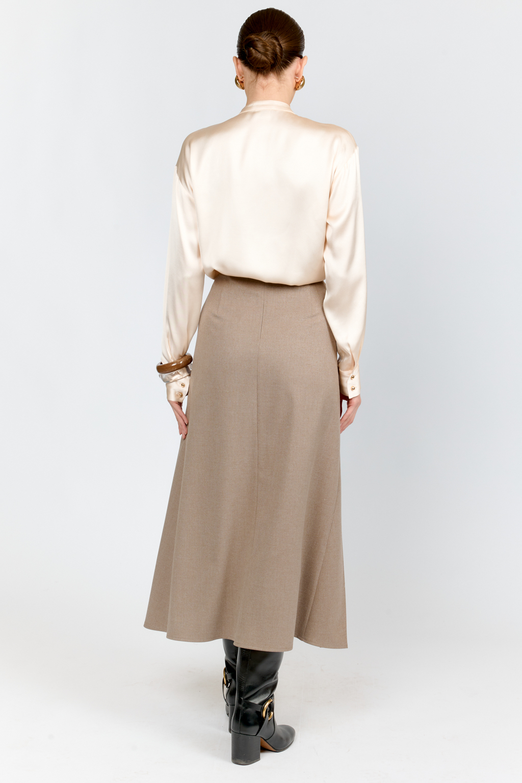 Блуза свободного кроя из шелковистой вискозы с интересной деталью в виде складки на горловине с застежкой на декоративную золотую пуговицу. Изделие придаст стильный акцент к любому образу.