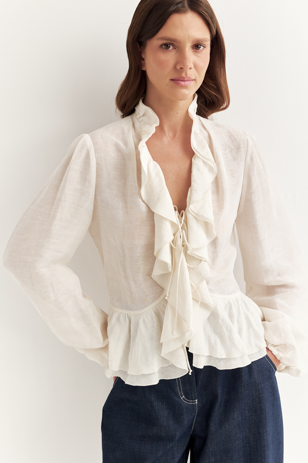 Блуза, выполненная в стиле бохо-шик, предстает в нежном и трендовом оттенке словочного масла. Ткань, сотканная из льна и вискозы, дарит ощущение легкости. Рюши изящно обрамляют борт и низ изделия, втачной рукав, слегка расширяющийся книзу, завершается мягким объемным манжетом. Блуза завязывается на шнуры-рулики.  Создавайте из этой блузы романтические образы, используйте ее также как второй слой для  многослойного сложного образа.