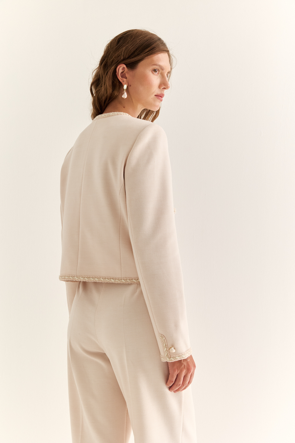 Жакет в стиле Chanel: вечная классика с характером. Икона женственности в новом прочтении — жакет в стиле Chanel с характерными элементами: округлым вырезом, выразительной декоративной тесьмой и крупными акцентными пуговицами. Прямой укороченный силуэт подчёркивает линию талии и делает модель идеальной как для офисного образа, так и для изысканного вечера. Накладные карманы добавляют практичности и шарма, а отделка по борту и рукавам формирует изящную рамку силуэта. Носите с юбкой, джинсами или брюками — он добавит статусности в любой комплект. Легендарный силуэт. Современное звучание.