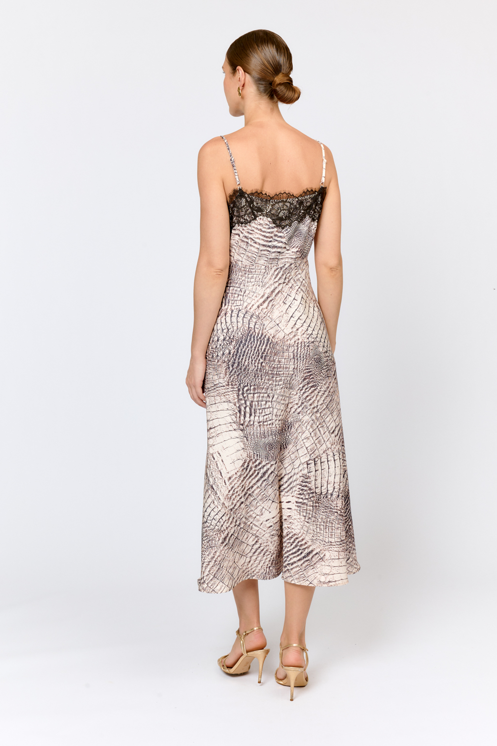 Платье-комбинация, скроенное по косой, на тонких бретелях и отделанное декоративным кружевом по верхней части. Длина платья  мидакси. Идеально для женственных образов для особых случаев и повседневной жизни в сочетании с базовыми жакетами, свитерами и кардиганами. Лаконичный крой,  подчеркивающий силуэт, обрамленная кружевом линия декольте делают образ соблазнительным и актуальным. Цветовое сочетание в дизайне принта позволяет легко  комбинировать изделие с другими моделями коллекции.