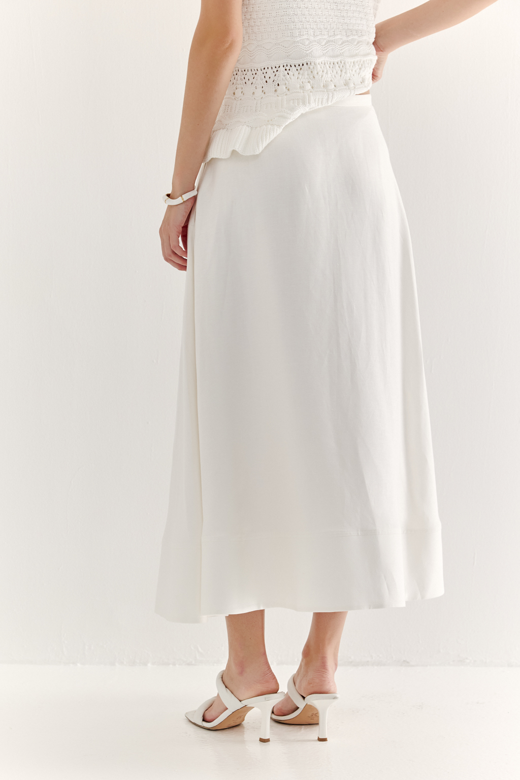 Юбка-миди, с силуэтом полусолнце, из уникальной ткани – 100% льняного твила белого цвета с эффектом air wash, является must-have наступающего сезона. Расширяющийся книзу силуэт дополнен притачным бордюром по нижнему краю, что подчеркивает женственность образа. Юбка имеет подкладку, узкий пояс и застежку на потайную молнию в боковом шве. Предлагаем носить эту юбку с льняными жакетами, а так же вязанными трикотажными топами.
