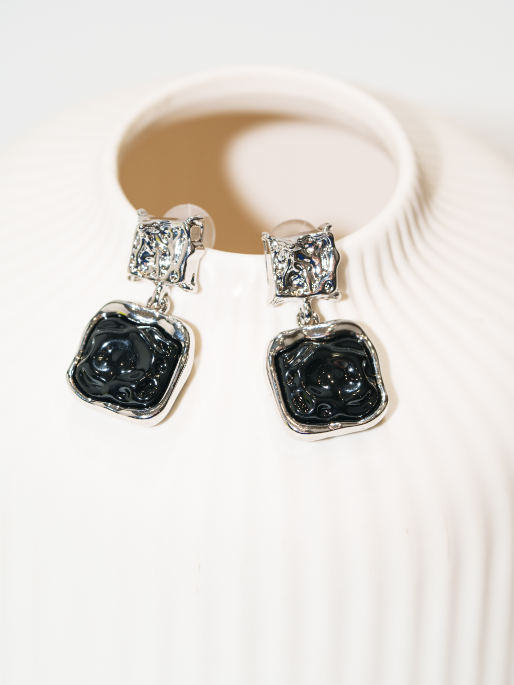 Лаконичные серьги из коллекции из металла серебряного и черного цвета объединяют геометрические формы и фантазийную фактуру. Украшение прекрасно дополняет практически любой стиль одежды и комплектуется с другими аксессуарами. Фурнитура выполнена из гипоаллергенного сплава со стойким гальваническим покрытием. Длина серег составляет 3 см, вес - 9 граммов.