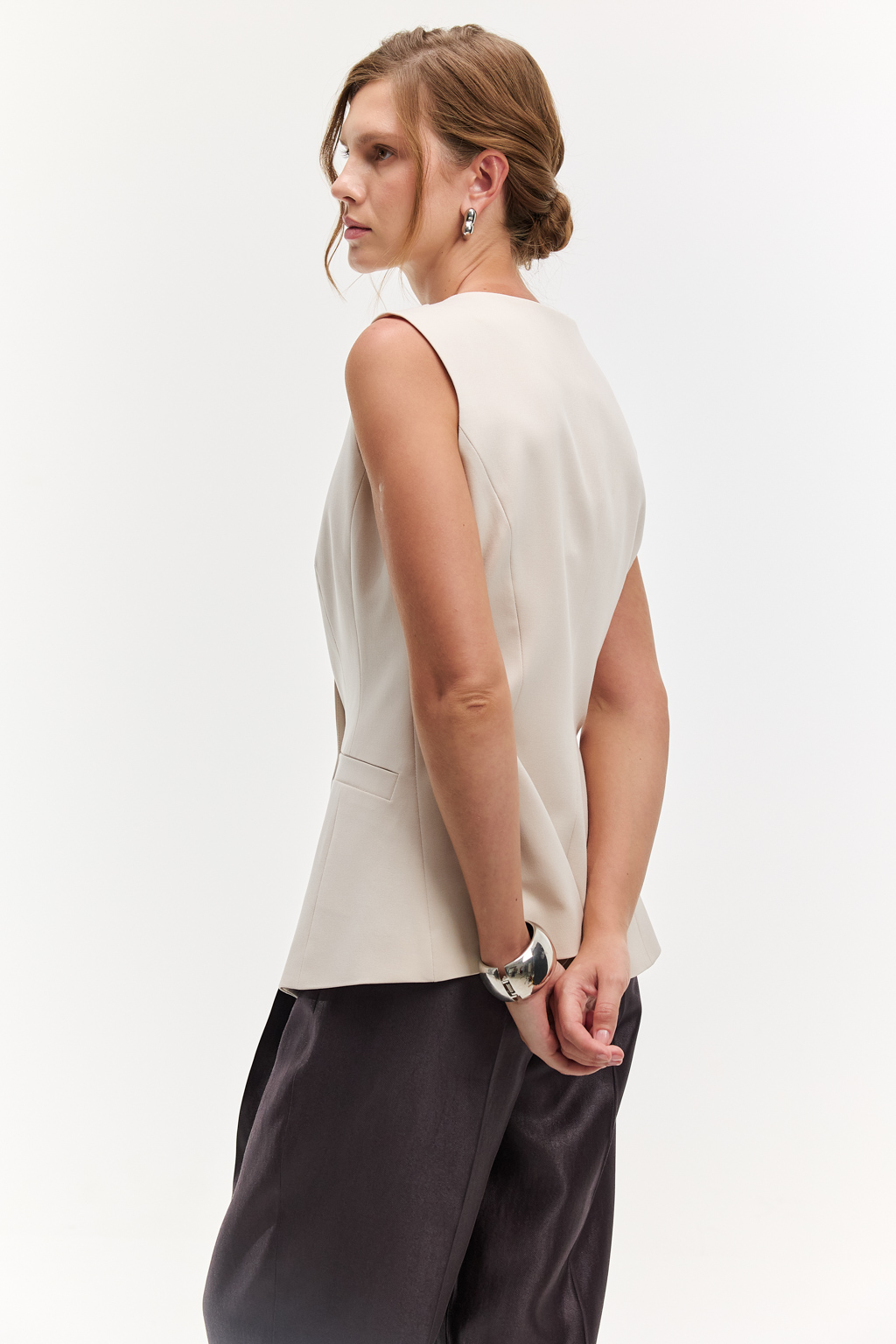 Жилет приталенного силуэта с асимметричным бортом и застежкой на декоративные пуговицы. Идеальный выбор для особых событий. Асимметричный дизайн и пуговицы делают модель уникальной. Комфортное сочетание шерсти, шёлка и вискозы обеспечивают идеальную посадку и сохраняют тепло и уют. Преимущества ткани: сочетание шерсти и шёлка создает премиальный эффект и уникальные тактильное ощущения. Материал держит форму, устойчив к износу. Гладкая поверхность выглядит дорого и изысканно. Жилет может стать предметом как первого слоя одежды, так и в второго.