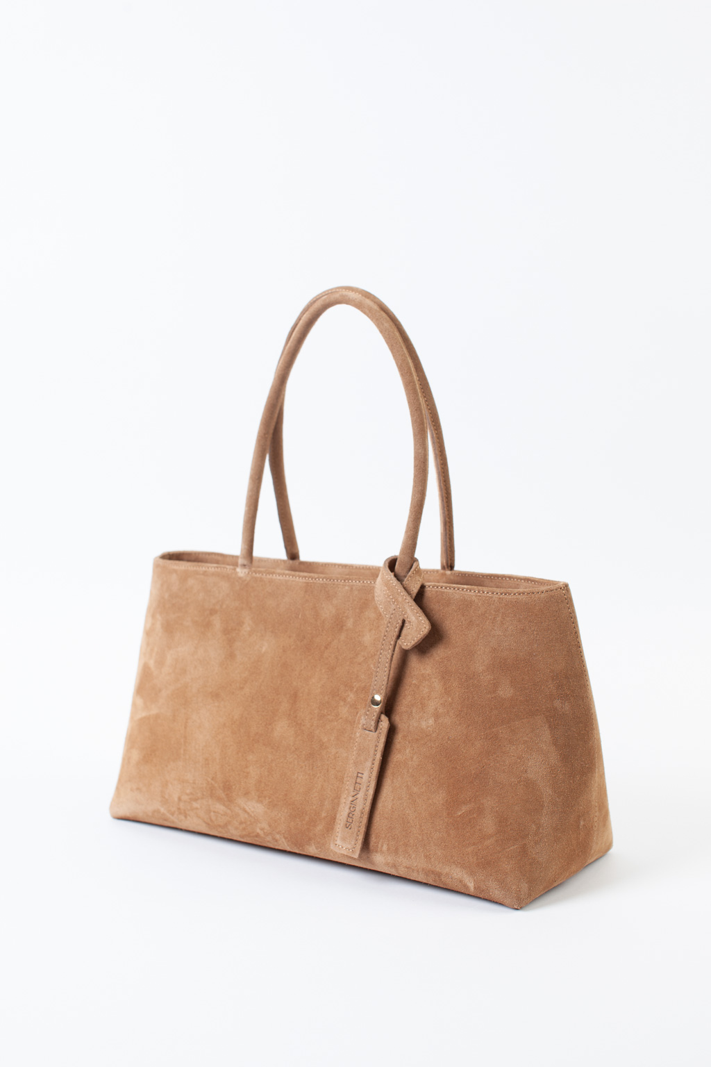 Сумка-тоут выполнена из натуральной замши. Аксессуар закрывается на металлическую молнию,имеет удобные ручки и брелок. Размеры сумки: 45*21*5,8 см.