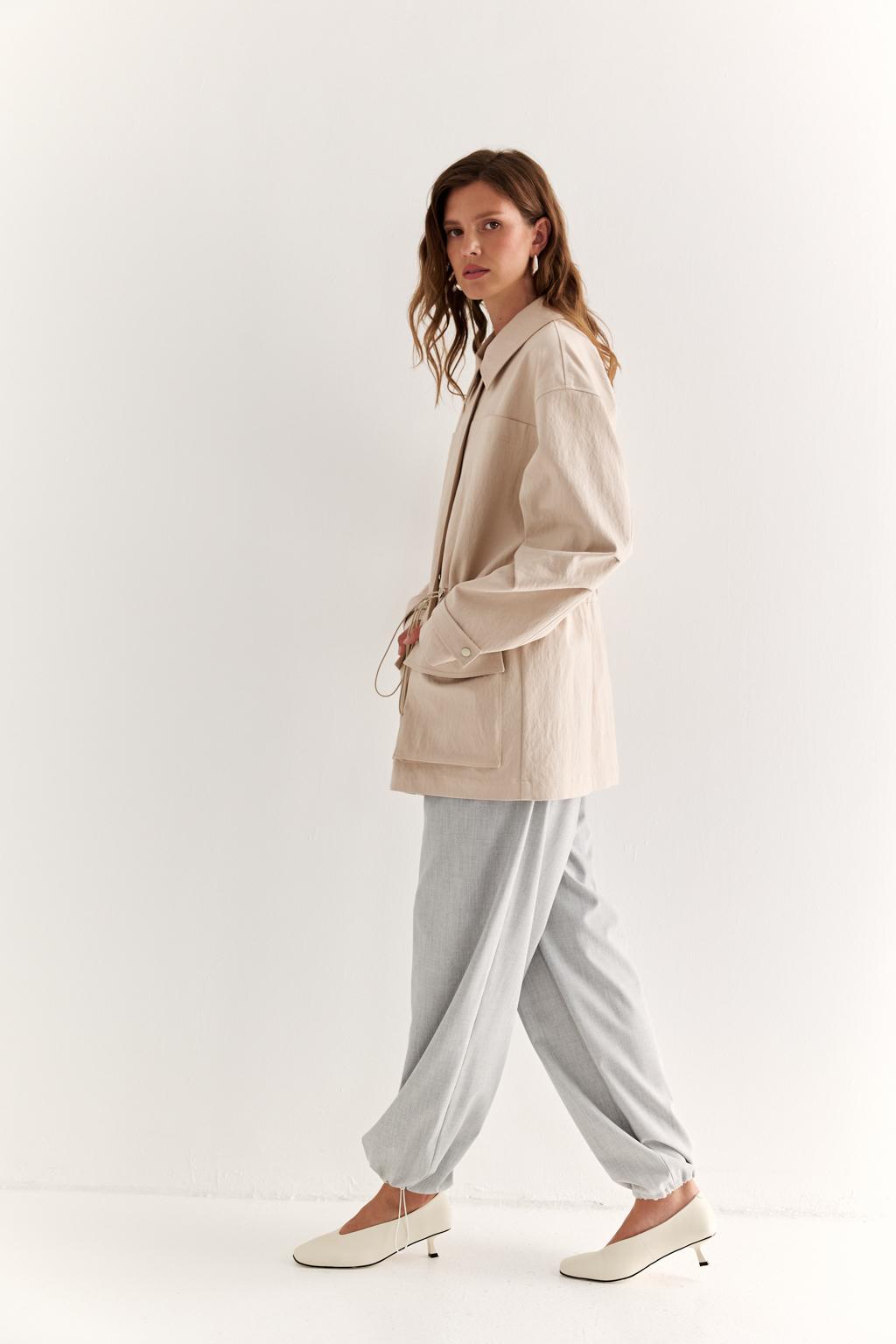 Куртка прямого силуэта длиной до бедер и с кулисой по талии. Воротник рубашечный, застежка под планкой. По полочке накладные карманы-портфели.