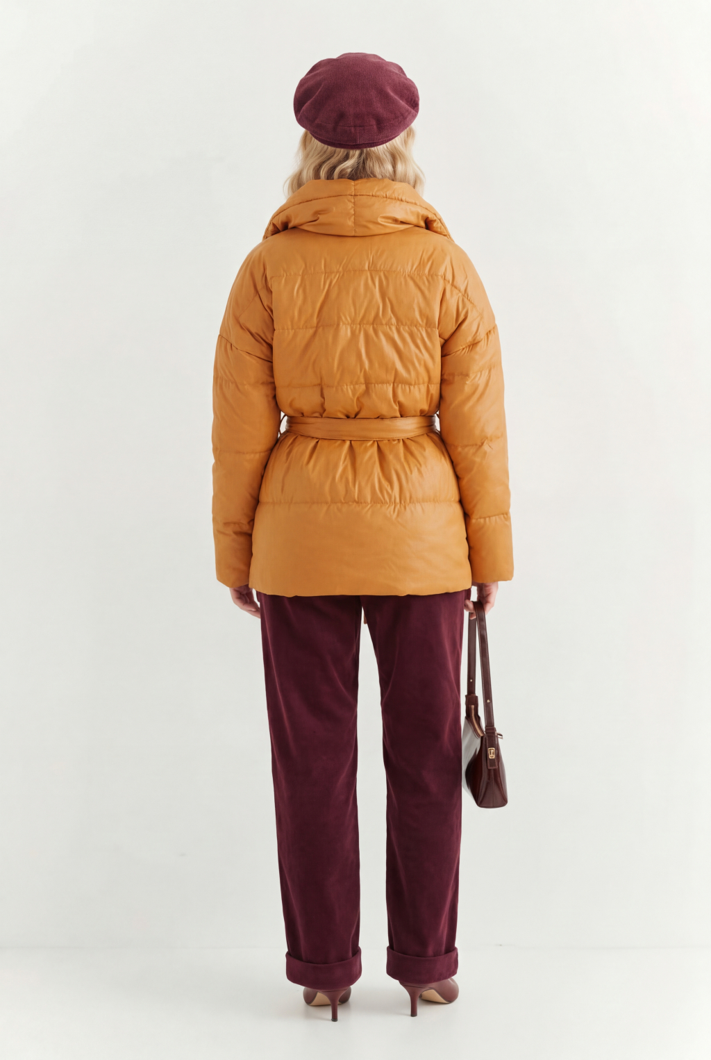 Короткий стеганый пуховик с английским воротником в горчичном цвете, застегивается на кнопки, имеет регулируемый пояс, что позволяет носить изделие в разных вариациях.