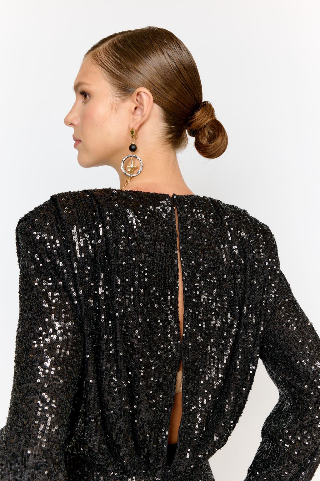 Праздничная блуза с мелкими глянцевыми пайетками с расширенной линией плеч и приталенного силуэта. По линии талии кокетка с застежкой сзади на потайные пуговицы. Ткани из полиэстера практичен в уходе, держат форму и устойчивы к сминанию. Преимущества ткани: умеренно блестящая, привлекающая  внимание ткань, для создания  эффектных образов. Пайетки придают изделиям уникальный блеск и сияние, делая их запоминающимися и праздничными.  Основа  - мягкая пластичная сетка, что делает изделие комфортным.