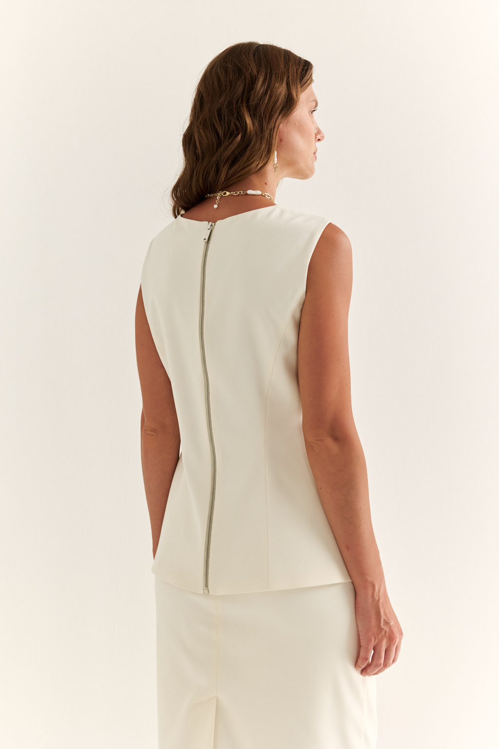 Жилет с акцентной талией: структура, которая вдохновляет
Жилет приталенного силуэта с удлинёнными линиями — элегантная альтернатива жакету в современном гардеробе. Вертикальные рельефы и чёткая посадка подчёркивают фигуру, визуально вытягивая силуэт.
Удлинённые углы полочек придают образу динамику, а отсутствие рукавов делает жилет универсальным элементом многослойных композиций. Идеален для деловых комплектов с брюками или юбками, а также в кэжуал-образах.
Форма, которая работает на стиль. Силуэт, который говорит за вас.