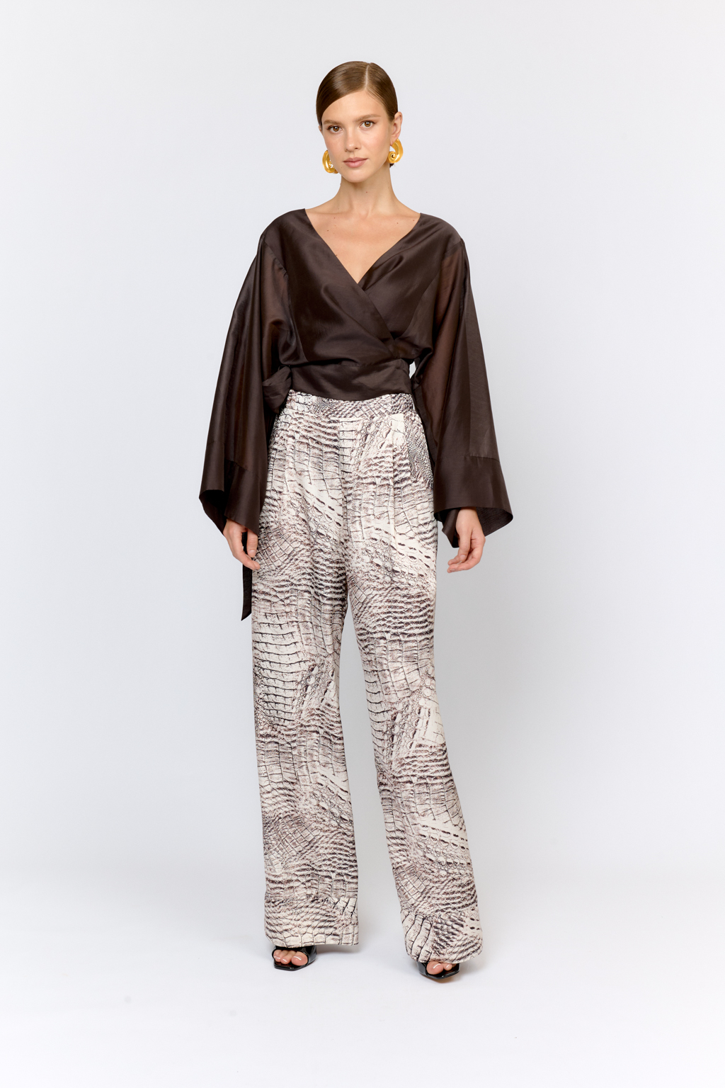 Брюки свободного силуэта с защипами с эластичным поясом на спинке . Свободный крой и струящаяся ткань делают модель комфортной в носке. Преимущества ткани: полиэстер добавляет прочности и практичности, сохраняя форму изделия. Ткань мягко драпируется, не сминается и не вытягивается, легкая и приятная на ощупь. Цветовое сочетание в дизайне принта позволяет комбинировать изделие с другими моделями коллекции.