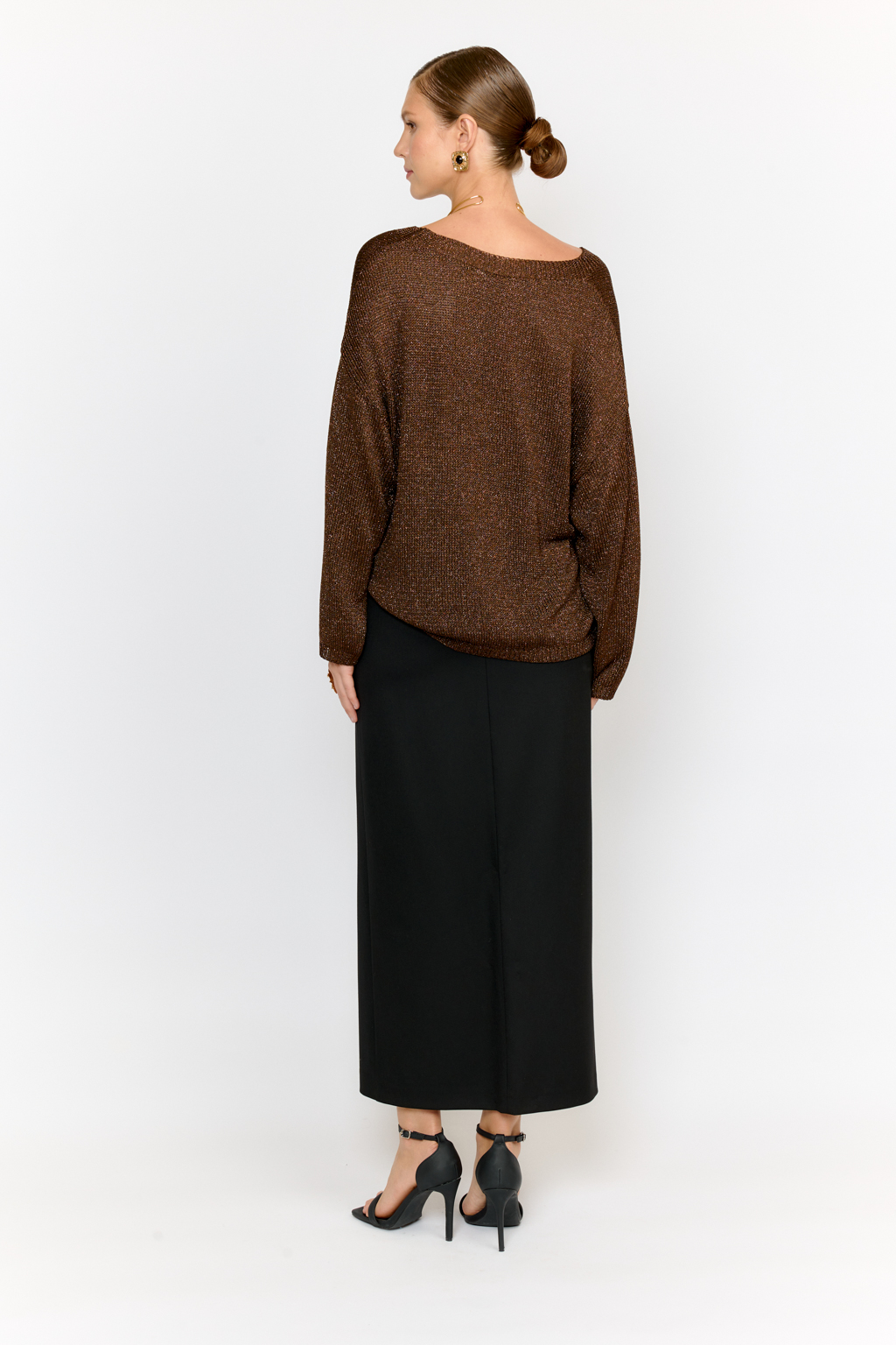 Модель джемпера с V-образным  вырезом горловины и свободным кроем выполнена из премиальной пряжи с вискозой в составе. Металлизированное волокно придает пряже  мерцание. Мягкие ниспадающие линии джемпера красиво драпируют фигуру. Базовая по крою модель, выглядит уникальной  благодаря эффектному металлизированному блеску и роскошному тёплому шоколадному оттенку.  Элегантный силуэт с длиной выше бедер и изящным V-образным вырезом подчеркивает женственность и создает безупречный образ.  Универсальный силуэт модели в сочетании с трендовым цветом поможет создать стильный образ на торжество или вечеринку.