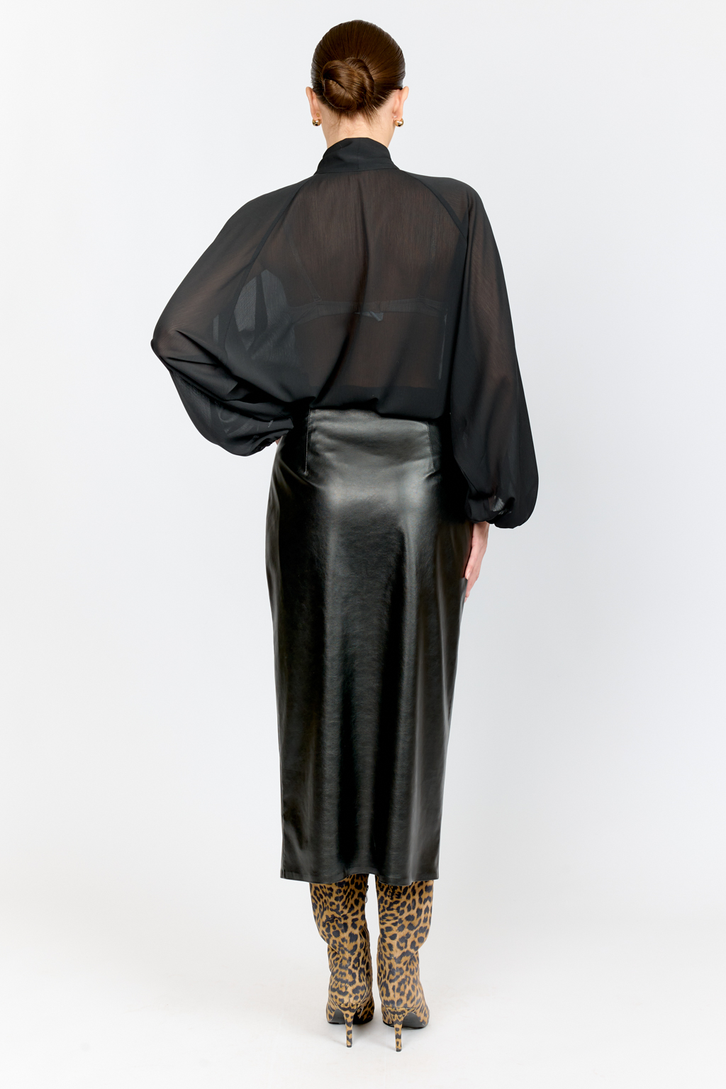 Юбка прямого кроя полуприлегающего силуэта с акцентной застежкой на металлическую молнию спереди из черной экокожи .