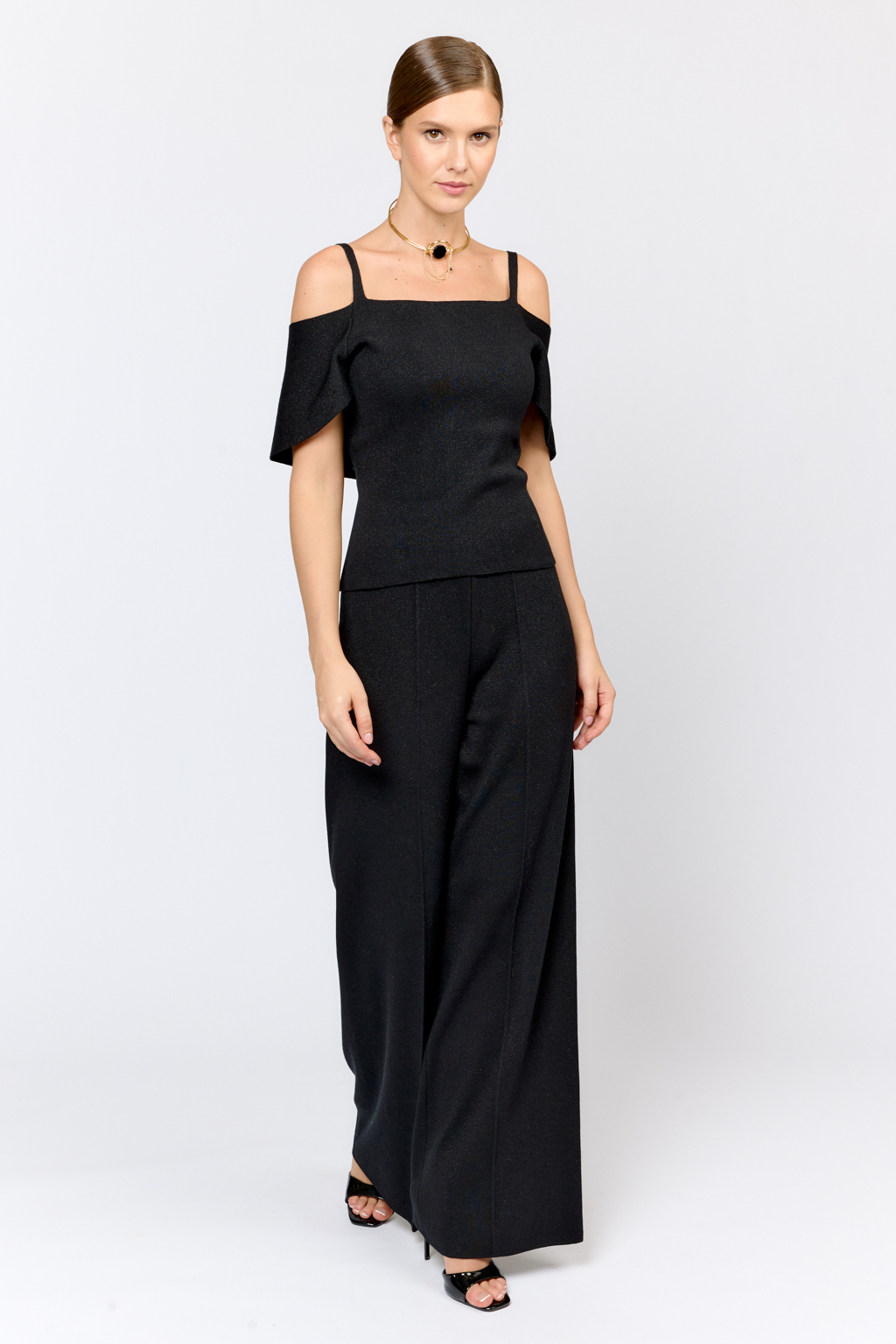 Топ на бретелях с открытыми плечами и пелериной. Качественный материал с эластаном и вискозой, классический черный цвет позволяет создавать образы на каждый день. Сочетайте с классическими брюками или юбками трапециями, джинсами для создания гармоничного комплекта.