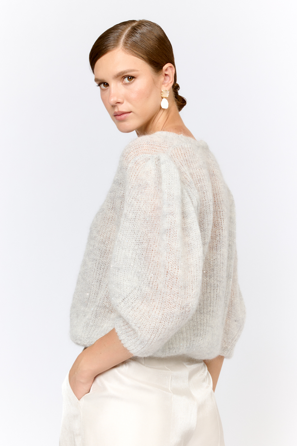 Легкий кардиган с центральной застежкой на пуговицы, V-образной горловиной и укороченным рукавом. Выполнен в премиальной пряже в составе которой, мохер и шерсть. Невесомый на вид, кардиган теплый и уютный. Мохер обладает множеством преимуществ: он легкий, обладает натуральным блеском, прочностью и долговечностью, отлично удерживает тепло. Кроме того, мохер устойчив к скатыванию и деформации. Модель кардигана умеренного объема с укороченным рукавом, идеальна для вечерних образов.