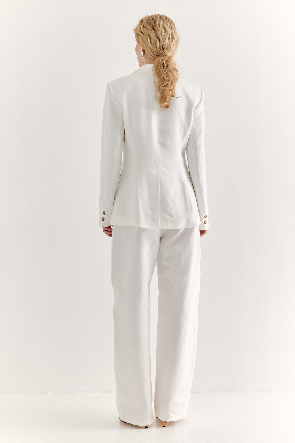 Приталенный классический пиджак с лацканами horn, застегивающийся на одну пуговицу, отличается слегка расширенной линией плеча и высокой шлицей в среднем шве спинки и отличной посадкой . Двушовные рукава дополнены шлицами на пуговицах. Этот пиджак в стиле Powerful Femininity, выполненный из уникальной ткани – 100% льняного твила белого цвета с эффектом air wash, является must-have наступающего сезона, идеально подходящим для создания актуальных образов с блузами, рубашками, шортами и брюками из льна и хлопка, а также с брюками и юбками, обладающими эффектом прозрачности и "крэш".