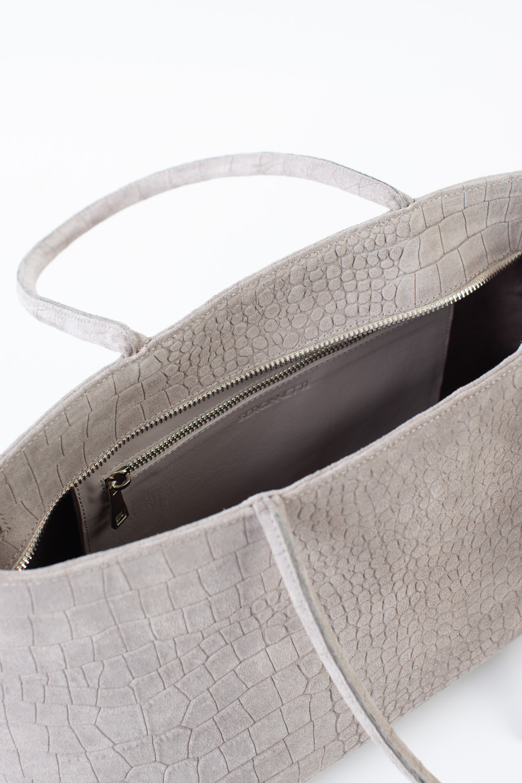 Сумка-тоут выполнена из высококачественного натурального спил-велюра с теснением под рептилию. Аксессуар закрывается на металлическую молнию, имеет удобные ручки и брелок. Размеры сумки: 45*21*5,8 см.