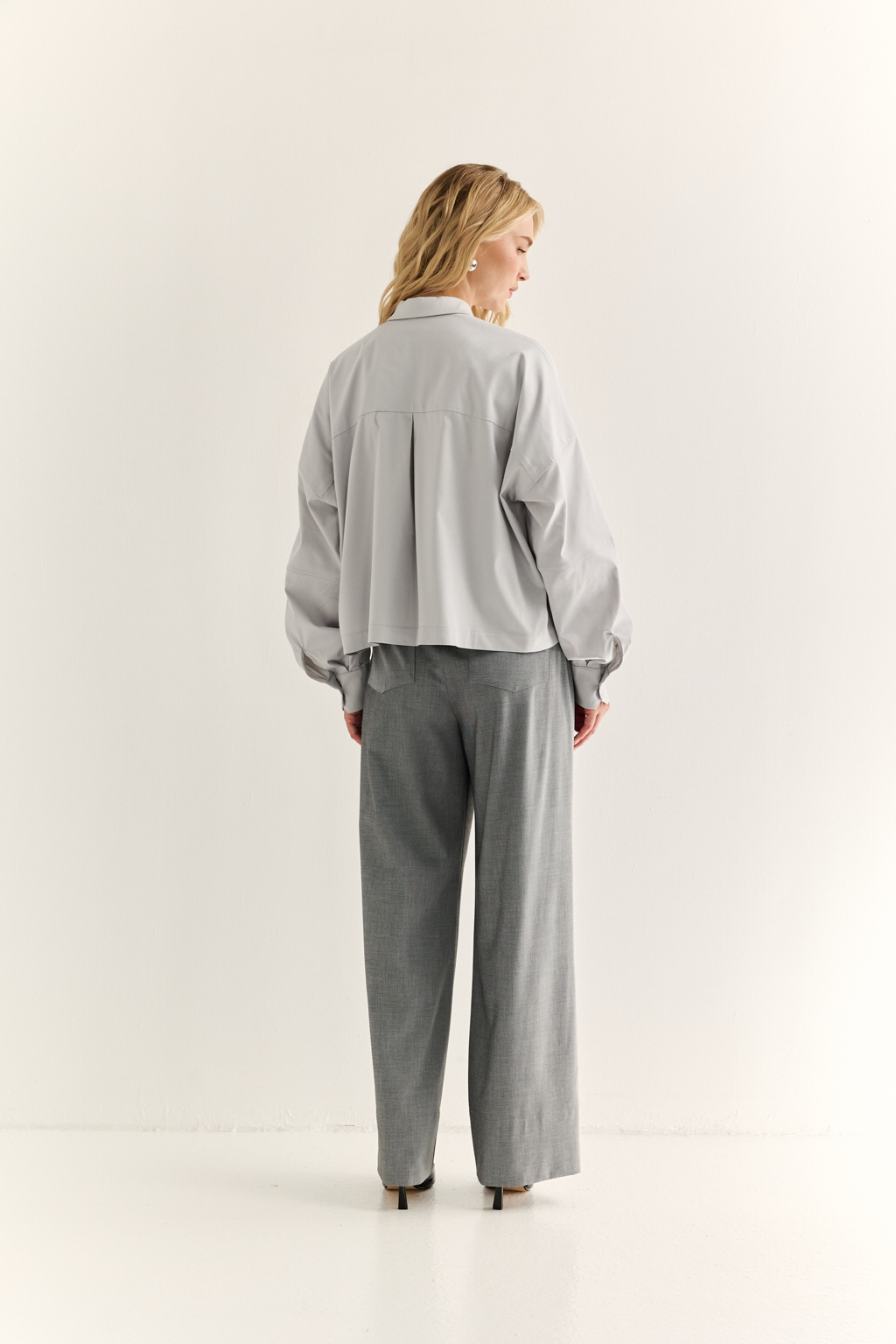 Oversize-рубашка: свобода в форме, точность в деталях

Эта укороченная oversize-рубашка — воплощение современного кроя и функционального стиля. Объёмные рукава с манжетами, акцентная застежка и выразительная спинка с декоративными элементами придают образу архитектурность и остроту. Маленький воротник и прямой  крой делают модель универсальной — от smart casual до модного street style.

Носите как самостоятельную вещь или как верхний слой поверх топа и платья. Особенно эффектно сочетается с брюками-карго, юбкой на высокой талии или джинсами.

Для тех, кто выбирает стиль с воздухом