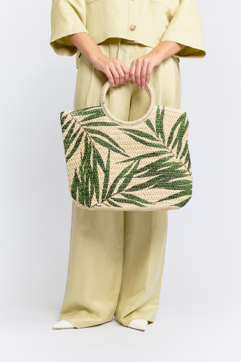 Плетеная сумка из качественной целлюлозы создана для настоящих ценительниц стиля и практичности. Яркий летний принт с листьями на светлом фоне напоминает о бохо стиле и легкости пляжной атмосферы. Вместительного размера сумка имеет внутренний кармашек, тканевый подклад и закрывается на кнопку. Круглая ручка обеспечивает комфортное ношение в руке, на запястье или логтевом сгибе. Размеры 30*22*37 см