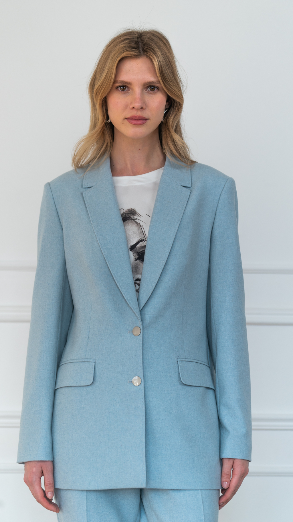 Жакет полуприлегающего силуэта с английским воротником и застежкой на две пуговицы. Длина до бедер. По воротнику декоративная отстрочка "ручной стежок"