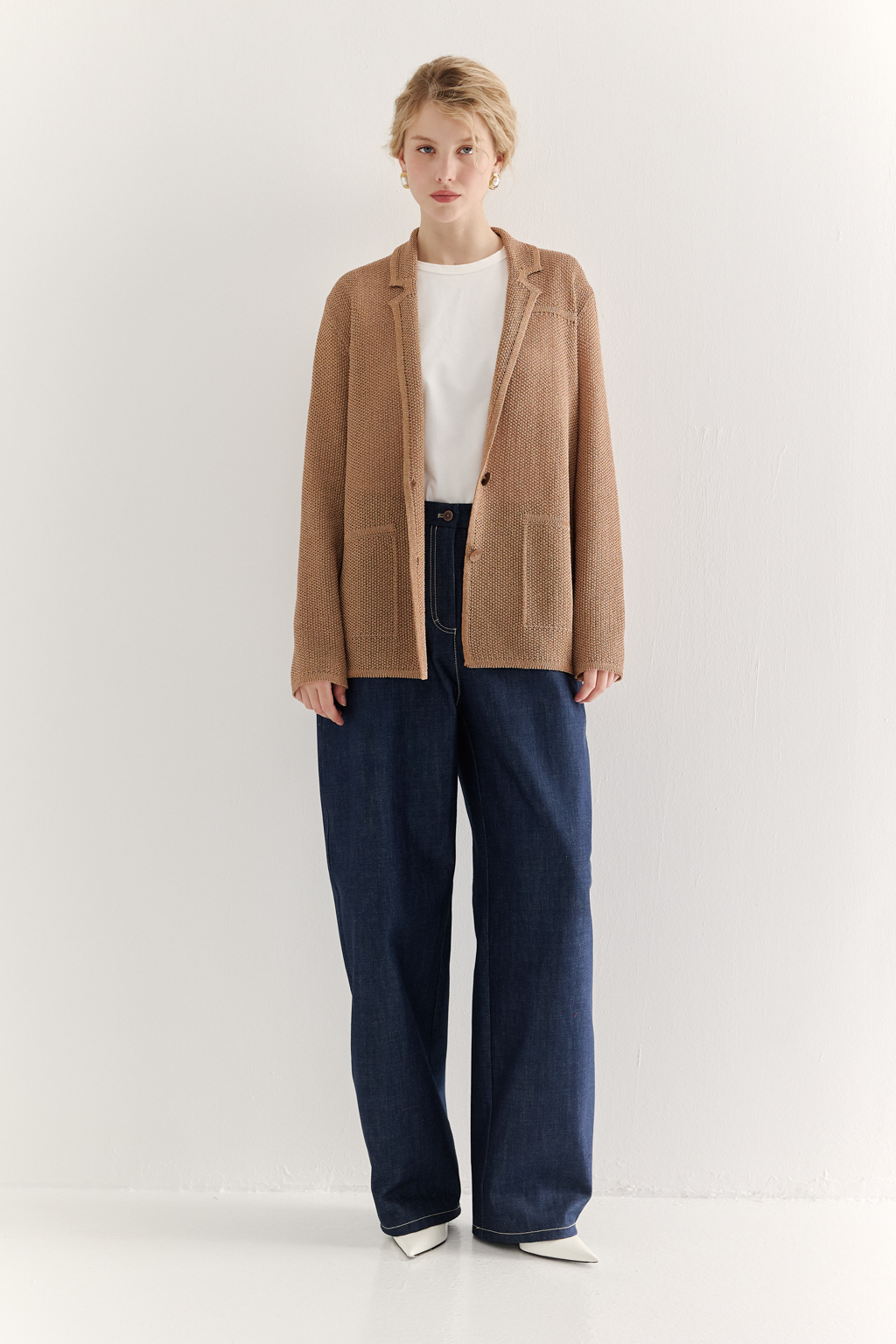 Жакет полуприлегающего силуэта  цвета бронзы из вязанного трикотажа, в составе которого вискоза и хлопок. Плотная скрутка нити образует упругое, но в то же время дышащее полотно. Цельно вязаные лацканы элегантно переходят в воротник, обрамляя вырез. Прямые рукава полной длины завершают лаконичный силуэт. Этот жакет станет изысканным дополнением к непринужденному городскому образу.