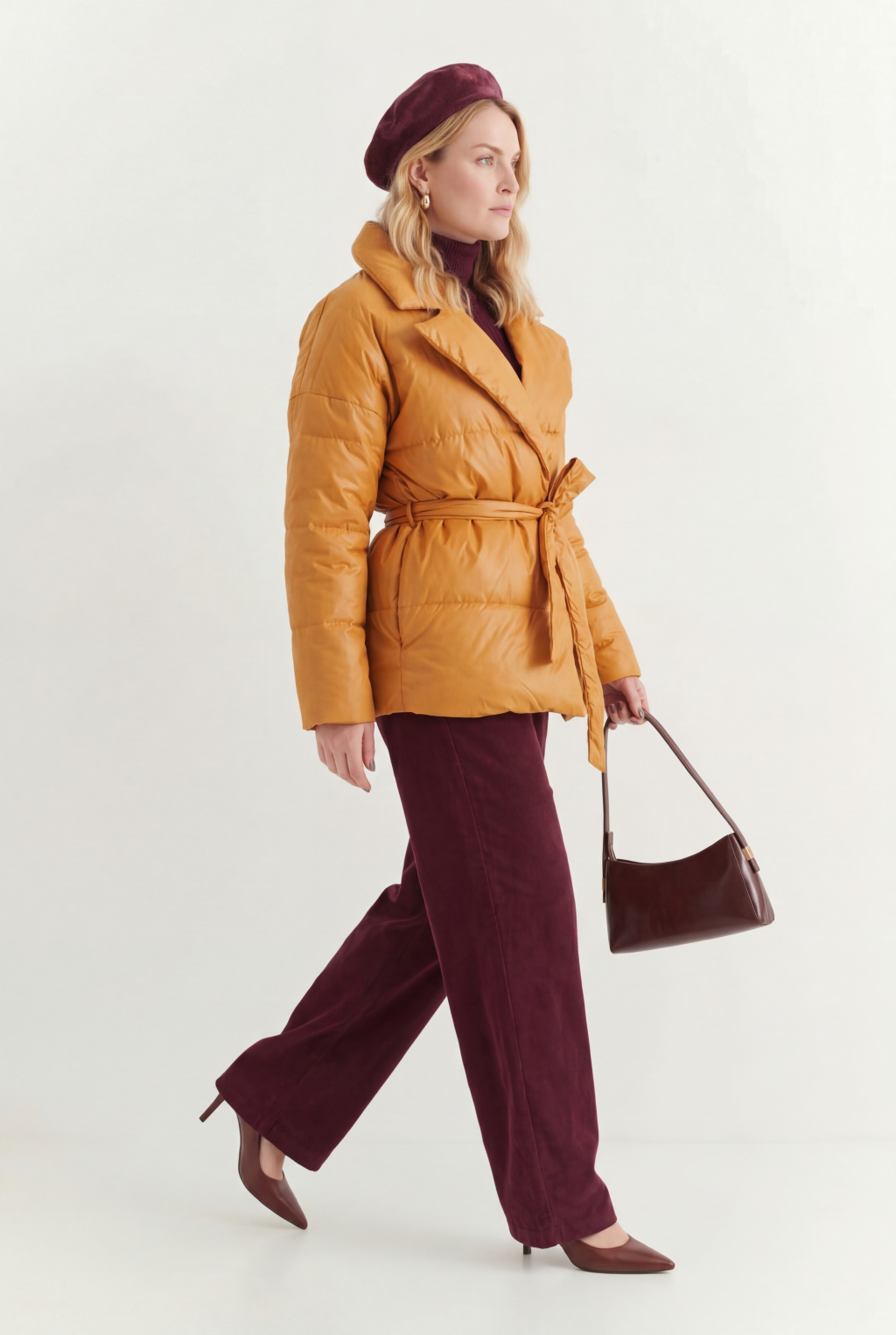 Короткий стеганый пуховик с английским воротником в горчичном цвете, застегивается на кнопки, имеет регулируемый пояс, что позволяет носить изделие в разных вариациях.