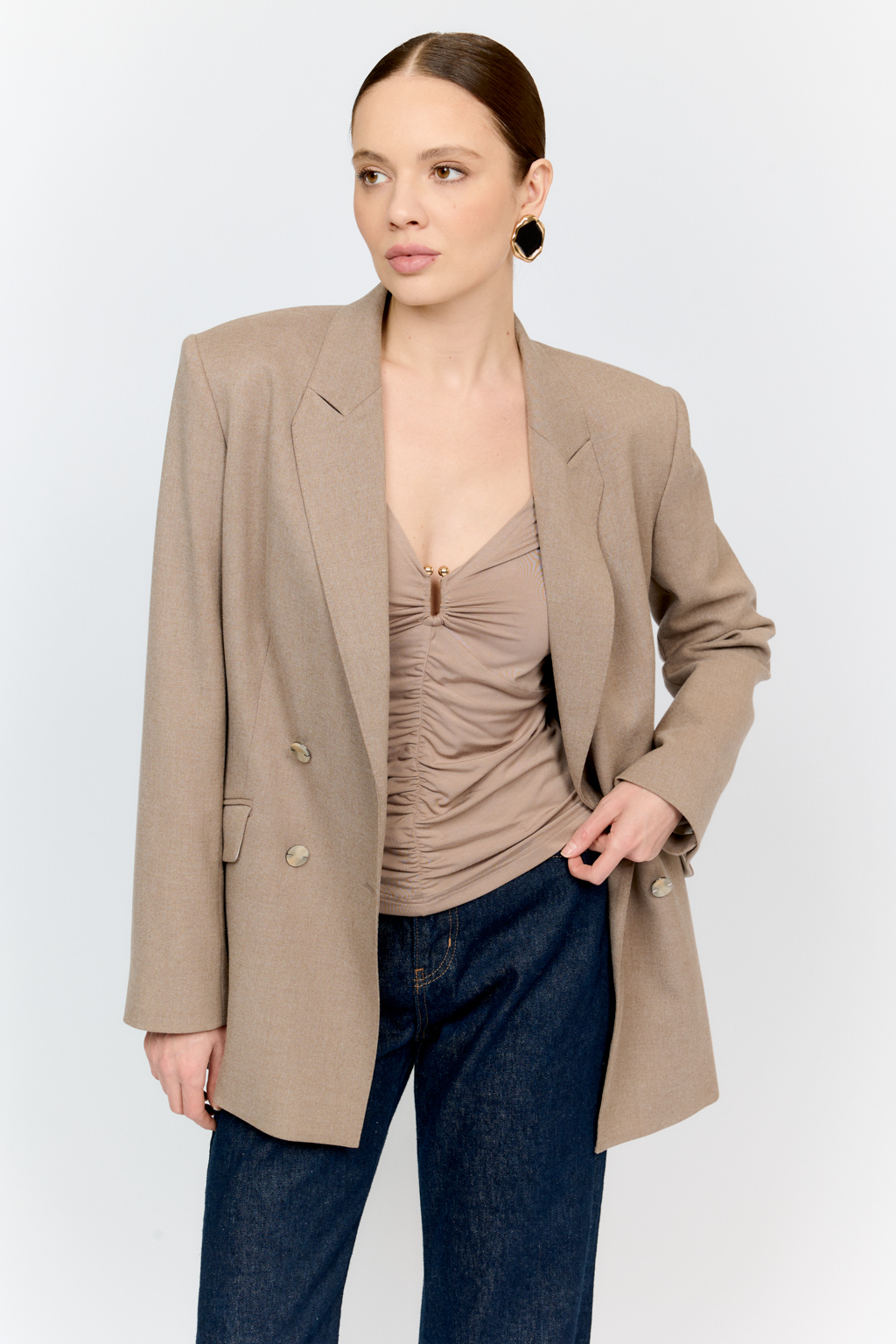 Лонгслив в цветет тофу с глубоким V-образным вырезом горловины и декором из металла в золотом оттенке. Спереди ткань драпируется в области груди и по средней линии полочки. Изделие подарит приятные тактильные ощущения в носке. Подойдет для стилизации со множеством образов.