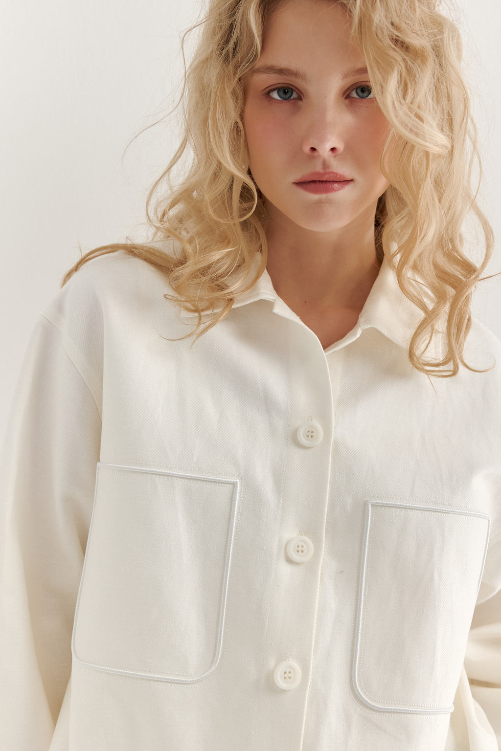 Парка-рубашка, выполненная из стопроцентного льна с диагональной выработкой, представляет собой прекрасный второй слой для летних образов. Скроенная по лекалам классической мужской рубашки, эта модель украшена 3D вышивкой, имитирующей накладные карманы. Планка с застежкой на пуговицы, рубашечный воротник со стойкой, широкие манжеты рукавов, кокетка спинки и вырезы внизу боковых швов подчеркивают уникальный дизайн этой модели. Завершает образ вышивка-слоган новой коллекции, расположенная на воротнике.