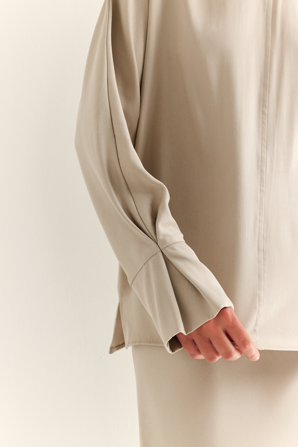 Блуза с цельнокроеными рукавами со складкой по манжету и V-образным вырезом по спинке.
