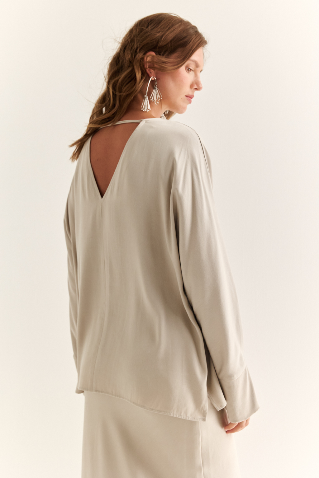 Блуза с цельнокроеными рукавами со складкой по манжету и V-образным вырезом по спинке.
