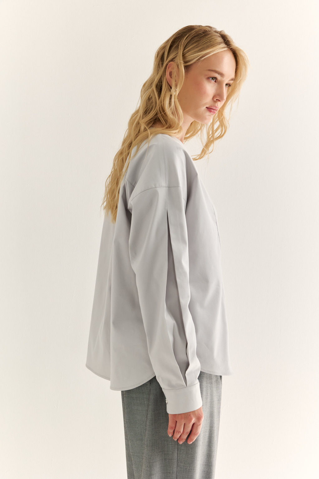 Блуза с V-вырезом: нежность в современном ритме. Эта блуза сочетает в себе деликатность форм и продуманную простоту. Глубокий V-образный вырез визуально вытягивает силуэт, а мягкие линии кокетки и рукавов добавляют романтичности. Объёмные рукава с манжетами и аккуратная застёжка на пуговицы завершают образ с лёгкой винтажной ноткой. Идеально смотрится в паре с юбками на высокой талии, широкими брюками или под жилет. Благодаря универсальному дизайну легко вписывается как в деловой, так и в вечерний гардероб. Лёгкость, которая подчёркивает внутреннюю силу.