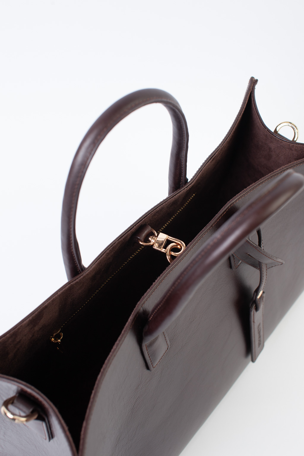 Стильная сумка через плечо глубокого шоколадного оттенка станет незаменимым спутником вашей коллекции. Простая, лаконичная форма идеально впишется в деловой образ. Вместительная модель выполнена из натуральной гладкой кожи с ручками сверху и дополнена ремешком через плечо. Размеры сумки: 39,7*25*14 см.