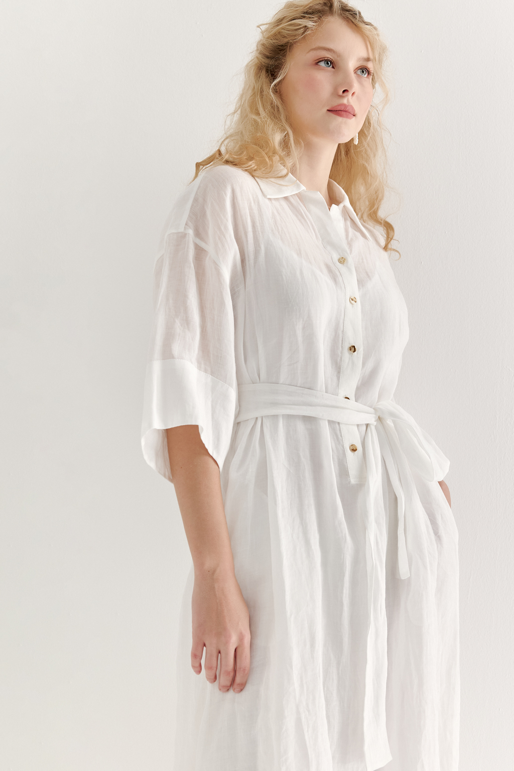 Это комфортное платье – традиционный образ для жаркого летнего дня. Платье изготовлено из воздушной невесомой вуали молочного цвета, в составе которой комфортный и экологичный материал крапива. Отложной воротник, планка для застежки, кокетка спинки, втачной широкий рукав одна вторая с отворотом, притачной бордюр по низу платья, пояс-самовяз и трапецивидный силуэт создают максимально комфортное образ. Возможно создание естственного крэш-эффекта, платье не требует сложного ухода.