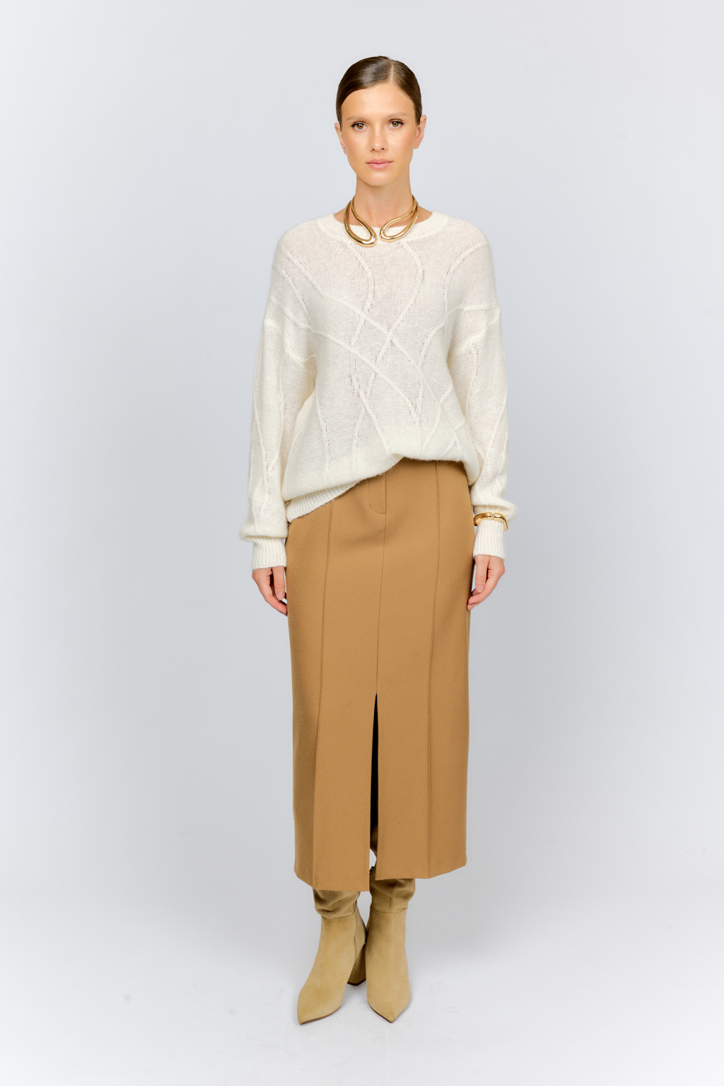 Нежный молочный  джемпер из мягкой шерстяной пряжи с трендовым ажурным дизайном, круглой горловиной, со спущенной линией плеча и длинными рукавами имеет  свободный силуэт оверсайз. Уникальный узор привлекает внимание и придает образу стильный акцент.