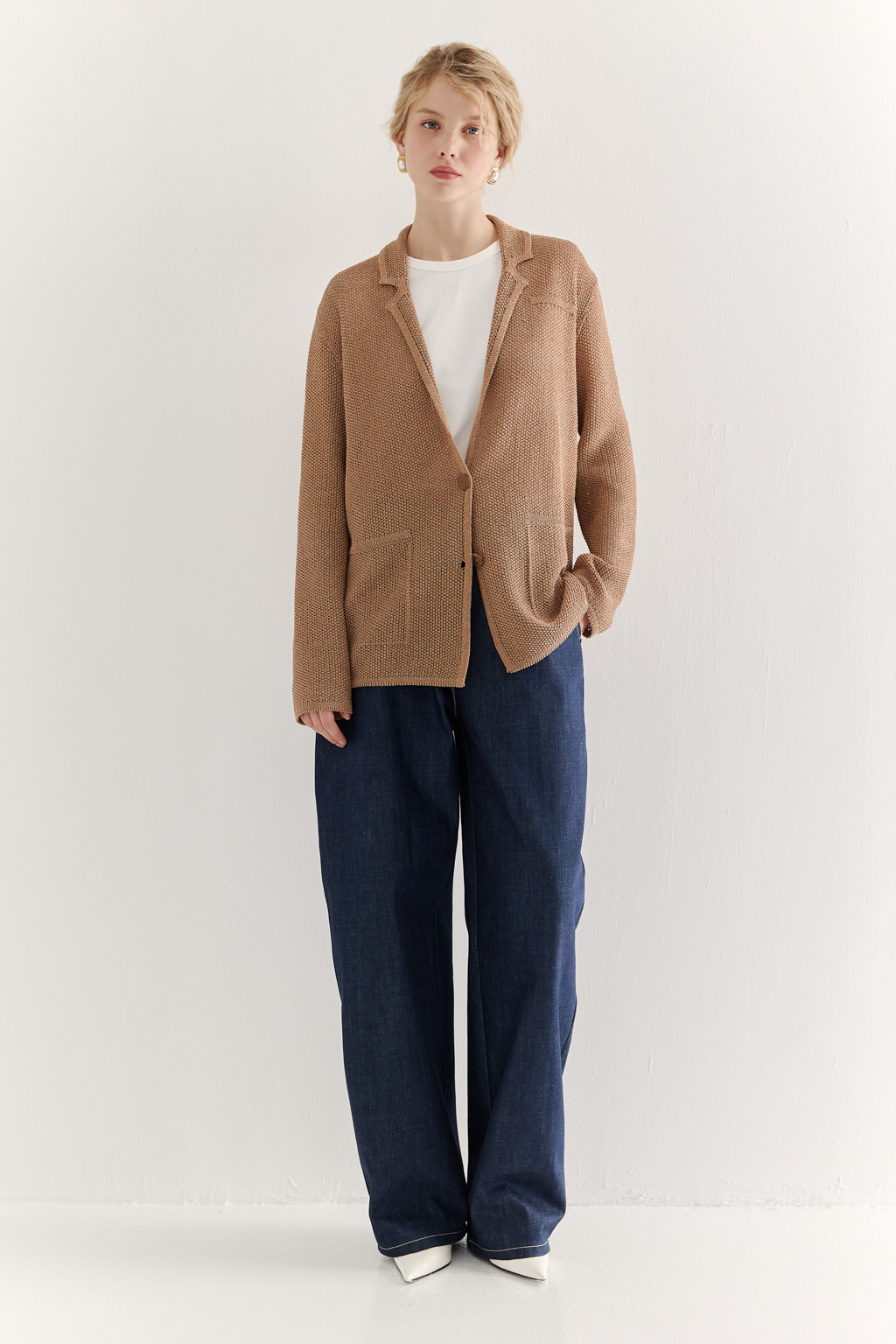 Жакет полуприлегающего силуэта  цвета бронзы из вязанного трикотажа, в составе которого вискоза и хлопок. Плотная скрутка нити образует упругое, но в то же время дышащее полотно. Цельно вязаные лацканы элегантно переходят в воротник, обрамляя вырез. Прямые рукава полной длины завершают лаконичный силуэт. Этот жакет станет изысканным дополнением к непринужденному городскому образу.