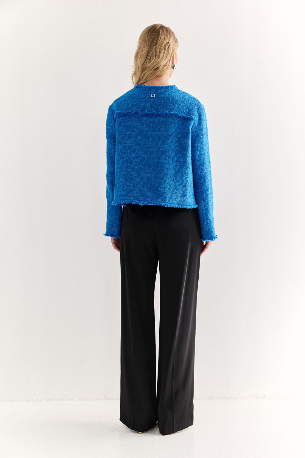 Жакет в стиле Chanel: текстура, изящество, характер
Икона стиля в современной интерпретации — укороченный жакет с застёжкой на крючки и декоративной бахромой по краям. Круглый вырез, слегка расклешенный силуэт и акцентные накладные карманы формируют элегантную геометрию, а текстурная отделка добавляет образу артистичной дерзости.
Эта модель легко становится центральным элементом образа — носите с юбкой, брюками или даже джинсами, создавая контраст между фактурой и формой. Идеальный выбор для женственного, но уверенного стиля.
Современная классика с французским акцентом.