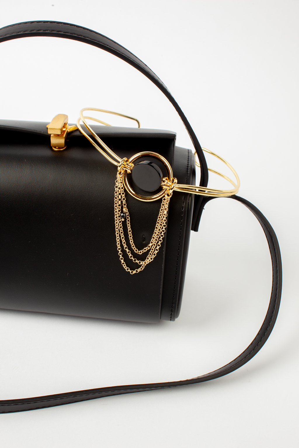 Колье обруч выполнено из металла золотого цвета со вставкой из черного агата. Дизайнерский стиль подчеркивается несколькими подвесками на цепи. Вся фурнитура выполнена из гипоаллергенного сплава со стойким гальваническим покрытием золотом. Длина колье составляет 34 см, вес: 37 гр.