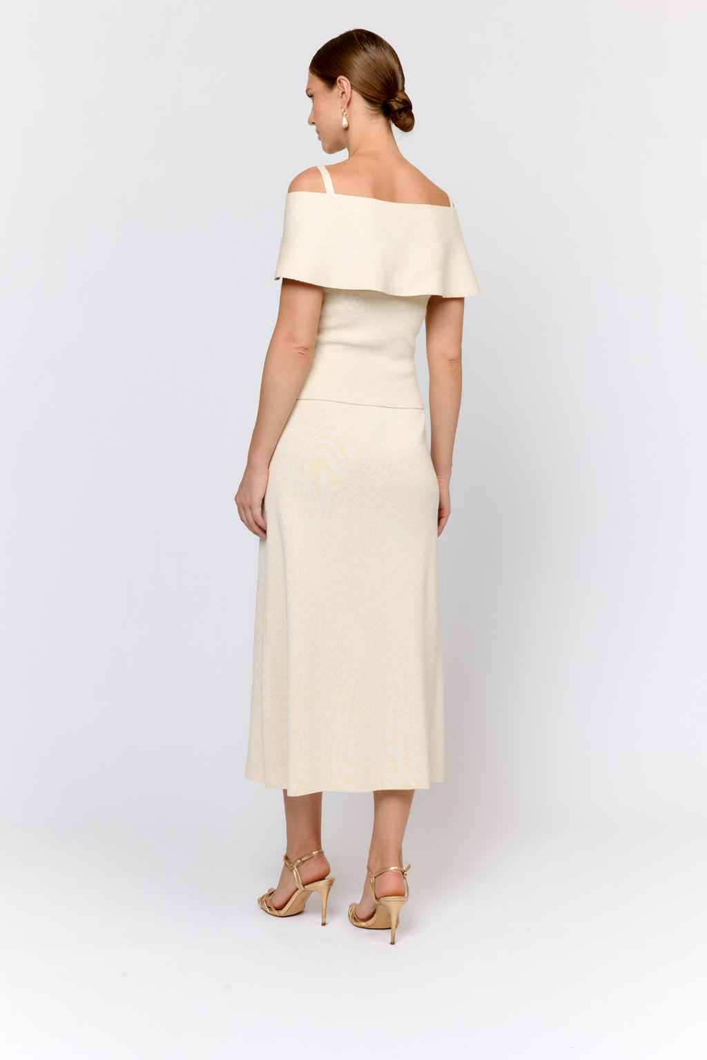 Топ на бретелях с открытыми плечами и пелериной. Оригинальный дизайн модели, подчеркивающий линию декольте и плечи воплощен в приятном к телу материале с вискозой в элегантном молочно-золотом цвете. Топ можно комбинировать с юбкой  или брюками из аналогичного материала. Или сочетать в образах с текстильными брюками из коллекции.