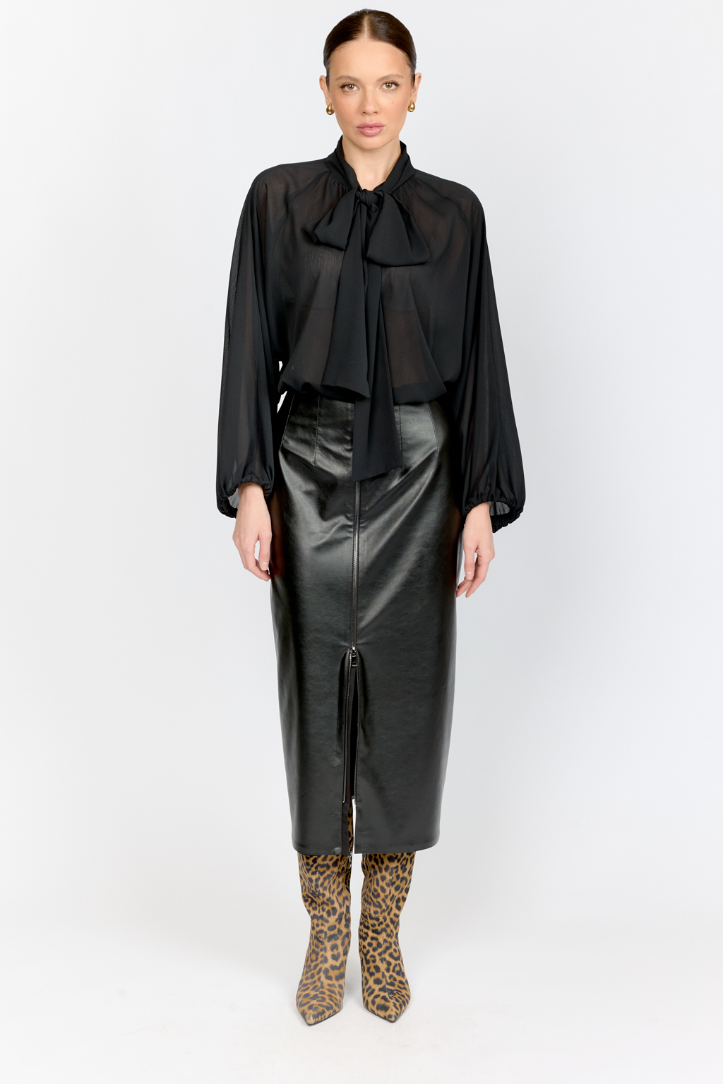 Юбка прямого кроя полуприлегающего силуэта с акцентной застежкой на металлическую молнию спереди из черной экокожи .