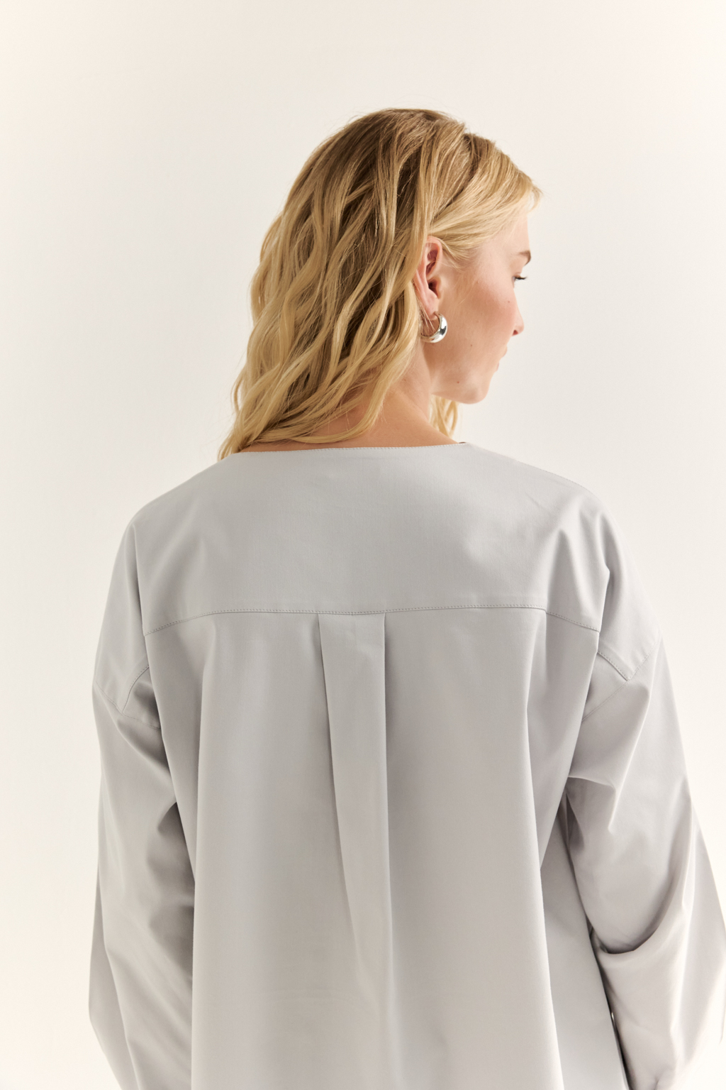 Блуза с V-вырезом: нежность в современном ритме. Эта блуза сочетает в себе деликатность форм и продуманную простоту. Глубокий V-образный вырез визуально вытягивает силуэт, а мягкие линии кокетки и рукавов добавляют романтичности. Объёмные рукава с манжетами и аккуратная застёжка на пуговицы завершают образ с лёгкой винтажной ноткой. Идеально смотрится в паре с юбками на высокой талии, широкими брюками или под жилет. Благодаря универсальному дизайну легко вписывается как в деловой, так и в вечерний гардероб. Лёгкость, которая подчёркивает внутреннюю силу.