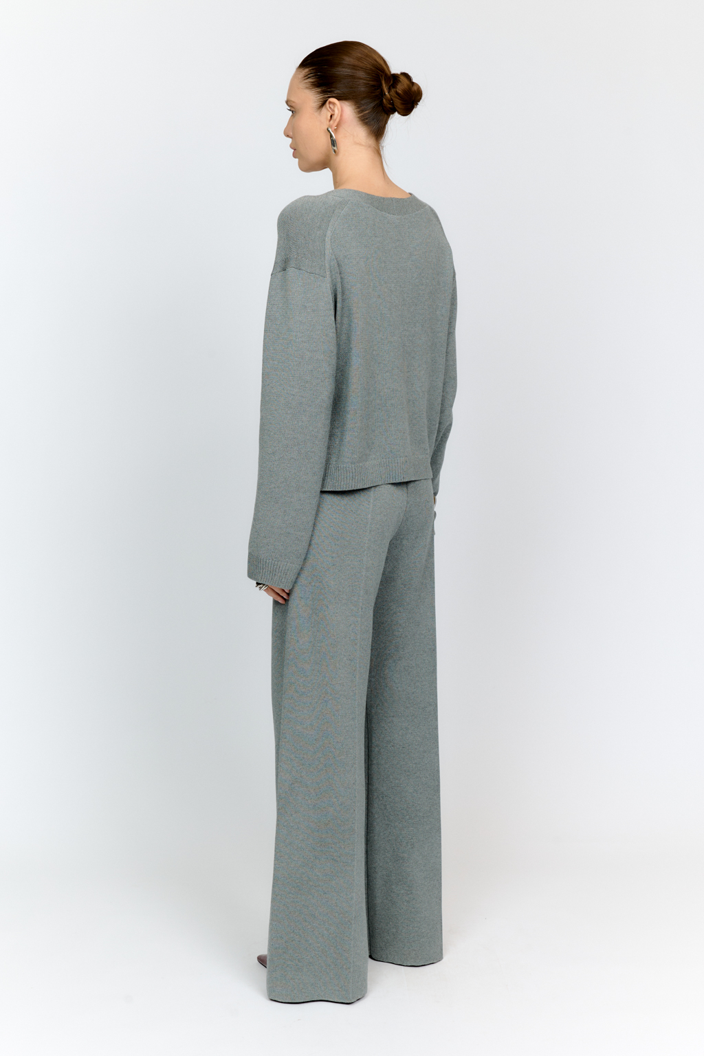 Трикотажный кардиган в сером цвете с V-образным вырезом горловины, на пуговицах, со втачным рукавом, двумя накладными карманами на полочке. Можно использовать в качестве альтернативы жакетам и носить вторым слоем в расстегнутом виде на более тонкие верха.