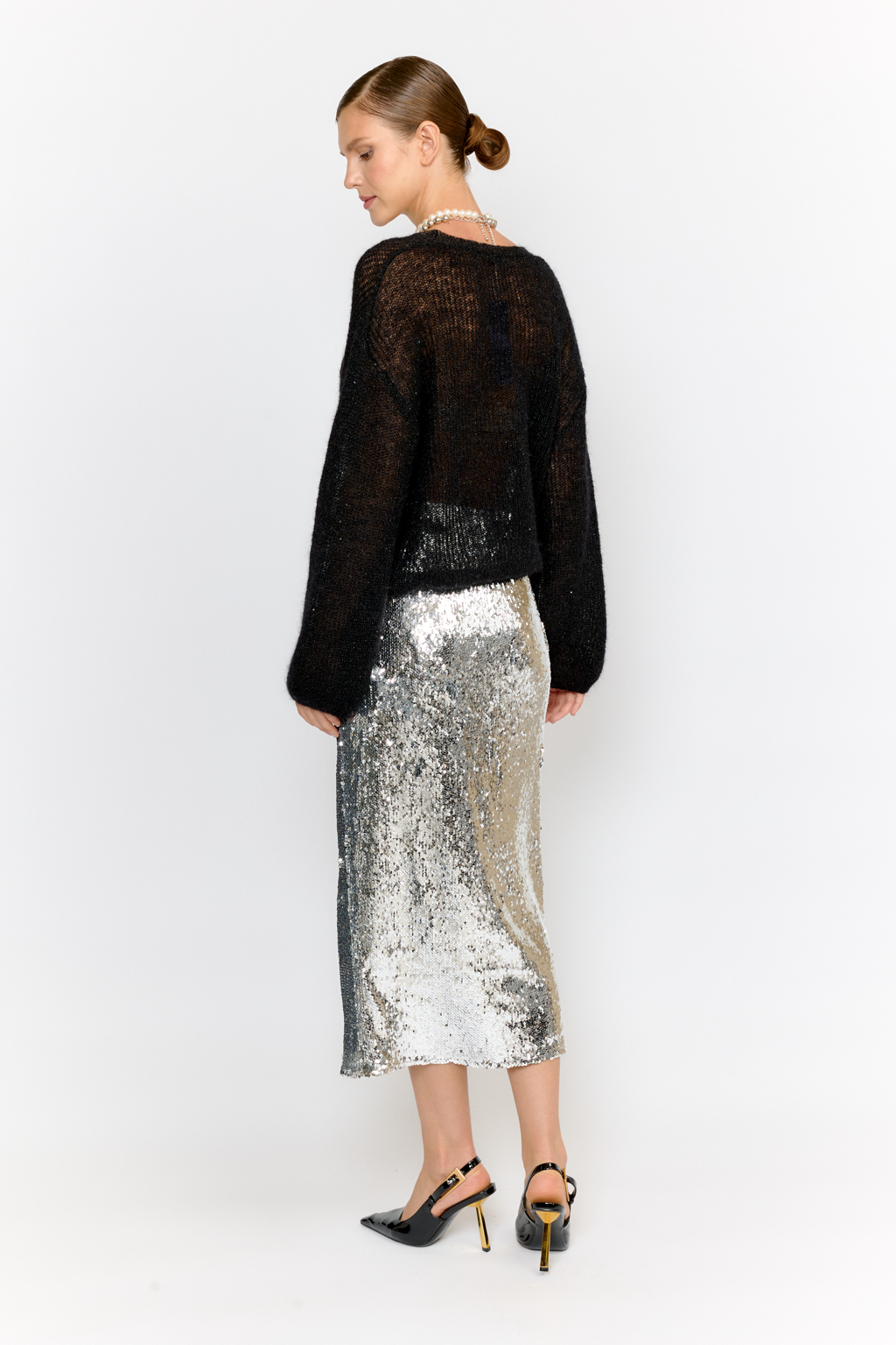 Кардиган с центральной застежкой на пуговицы, V-образной горловиной и длинным рукавом.  Модель свободного силуэта в глубоком черном  оттенке из воздушной пряжи с шерстью и мохером с деликатными мелкими пайетками, придающими легкое сияние. Кардиган очень теплый, несмотря но свою трендовую транспарентность и легкость, благодаря мохеру в составе. Шерсть так же обеспечивает естественную терморегуляцию и уют. Такой кардиган будет выигрышно смотреться в образах с  брюками и юбками из коллекции, а так же дополнит образы с платьями на бретелях или платьем-бандо.