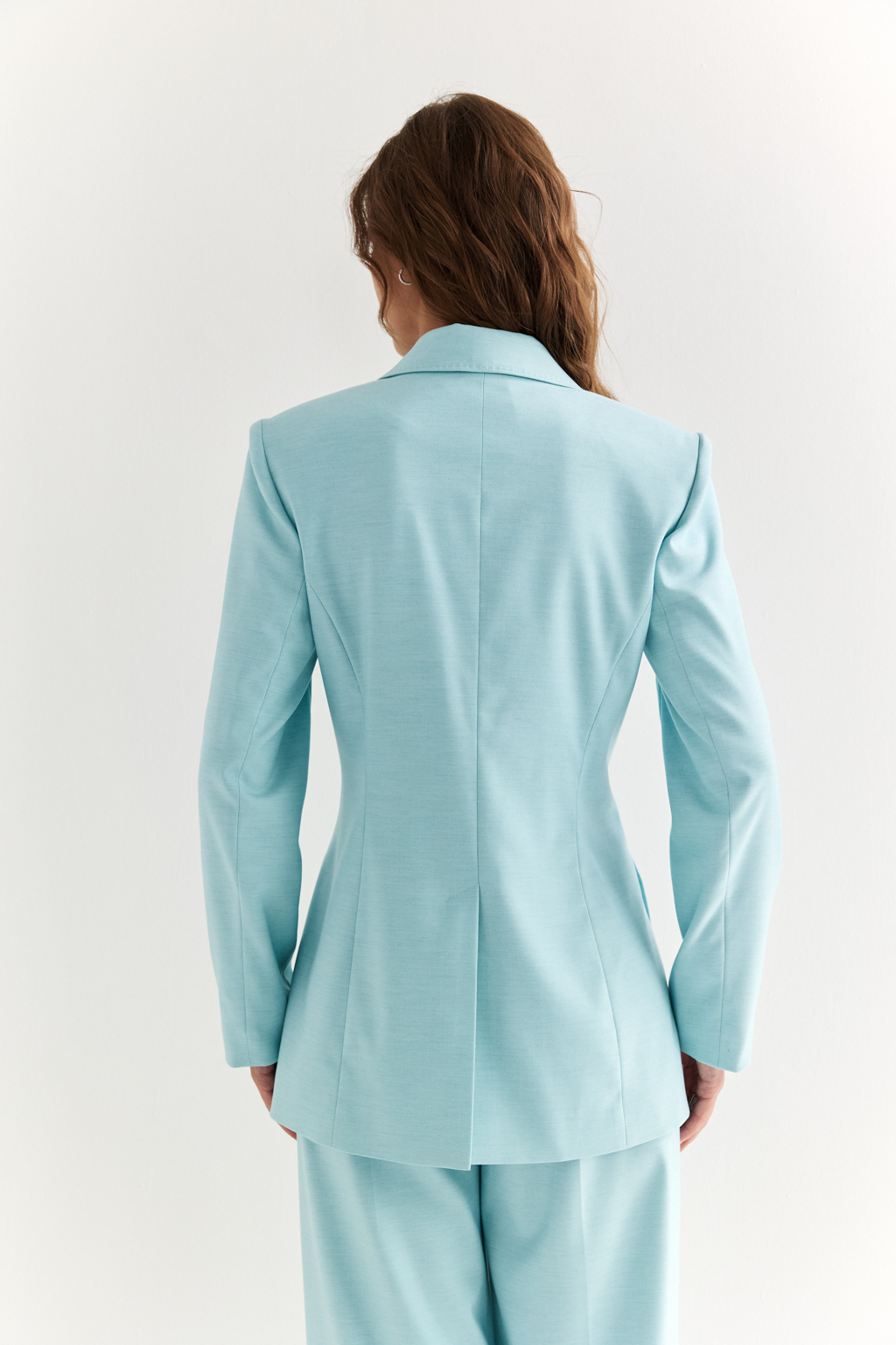 Приталенный жакет: акцент на силуэт и уверенность. Классический жакет со смещённой застёжкой и декоративными складками, подчёркивающими талию, — это вещь, которая формирует образ с первого взгляда. Чёткие линии плеч, заострённые лацканы и приталенный крой создают силуэт, говорящий о силе, вкусе и уверенности. Асимметричная застёжка добавляет изящную детализацию, а универсальная длина делает модель уместной как в деловом комплекте, так и в стилизациях с джинсами или платьями. Идеально садится и подчёркивает фигуру. Современная классика для женщины, которая знает, чего хочет.