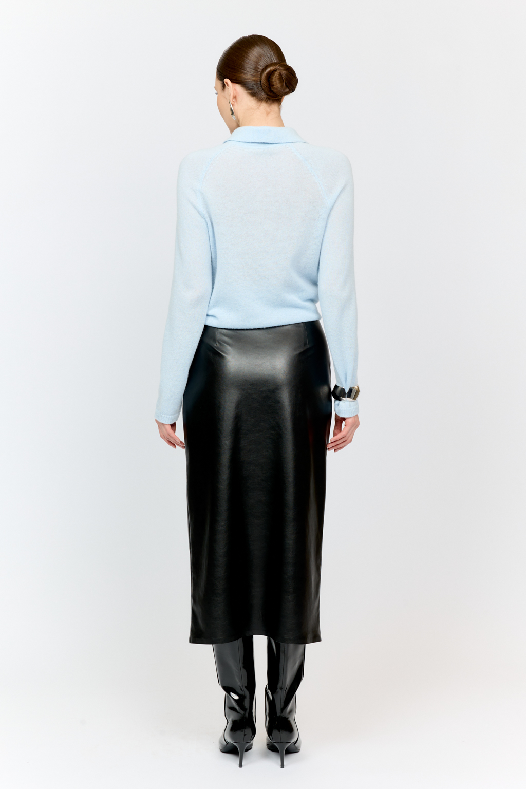 Юбка прямого кроя полуприлегающего силуэта с акцентной застежкой на металлическую молнию спереди из черной экокожи .