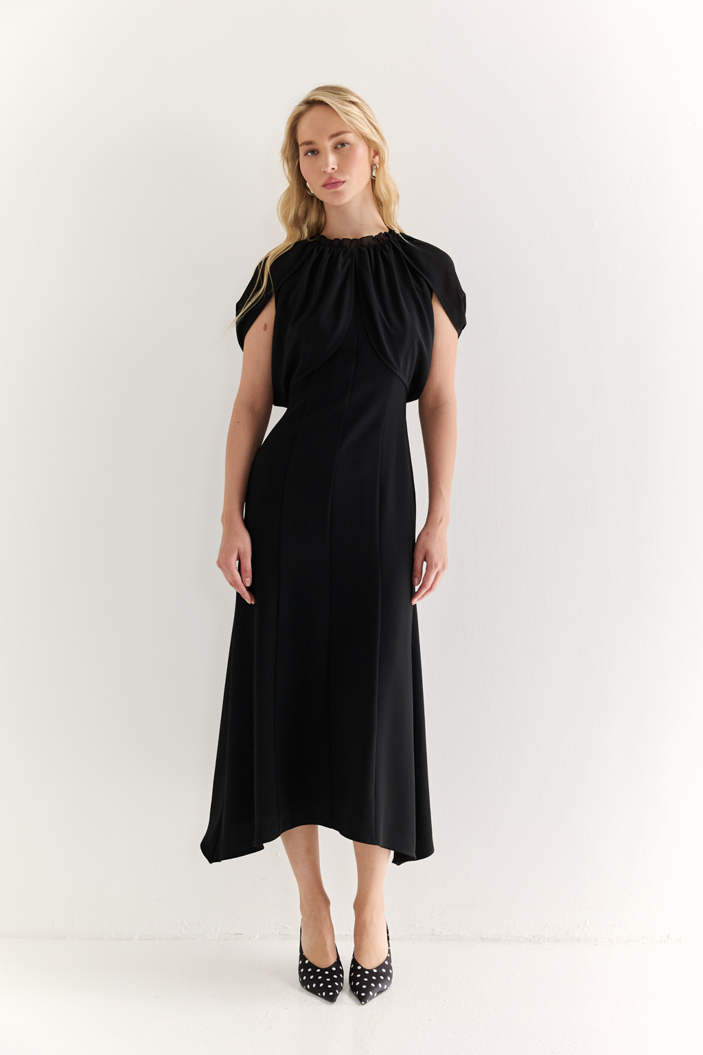 Платье с эффектом лепестков и шифоновой драпировкой: утончённая женственность в движении

Это платье словно создано для того, чтобы подчеркнуть красоту силуэта и придать образу воздушности. Драпировка на плечах из полупрозрачного шифона формирует эффект лепестков, мягко окутывая верх и придавая образу лёгкость, загадочность и изысканность.

Приталенный крой с расклешённой нижней частью визуально вытягивает фигуру и подчёркивает талию. Шифон не только добавляет деликатной динамики, но и создаёт выразительный контраст с плотной основной тканью, подчеркивая архитектуру платья.

Идеально подойдёт для вечерних выходов, приёмов и особых событий, где важна не только элегантность, но и уникальность подачи.

Воздушная графика. Платье, в котором ткань говорит языком чувственности.