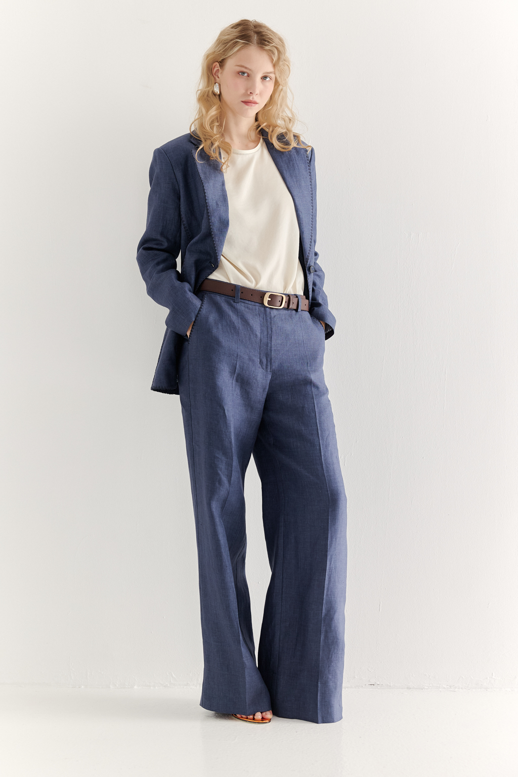 Эти брюки прямого силуэта созданы для абсолютного комфорта и расслабленной элегантности. Выполненные из ткани премиум-класса в шоколадном оттенке, они дарят невероятное ощущение мягкости и комфорта. Состав: стопроцентный лен с эффектом air wash. В дизайне этих брюк нашли отражение элементы мужского кроя: застёжка-гульфик, пояс со шлевками и удобные карманы. Входы в карманы отделаны с помощью декоративного петельного шва.  Широкая подгибка позволяет регулировать длину брюк посредством отворота-манжета, создавая элегантный акцент по низу. Брюки идеально дополнят городской look с льняным жакетом и трикотажем.