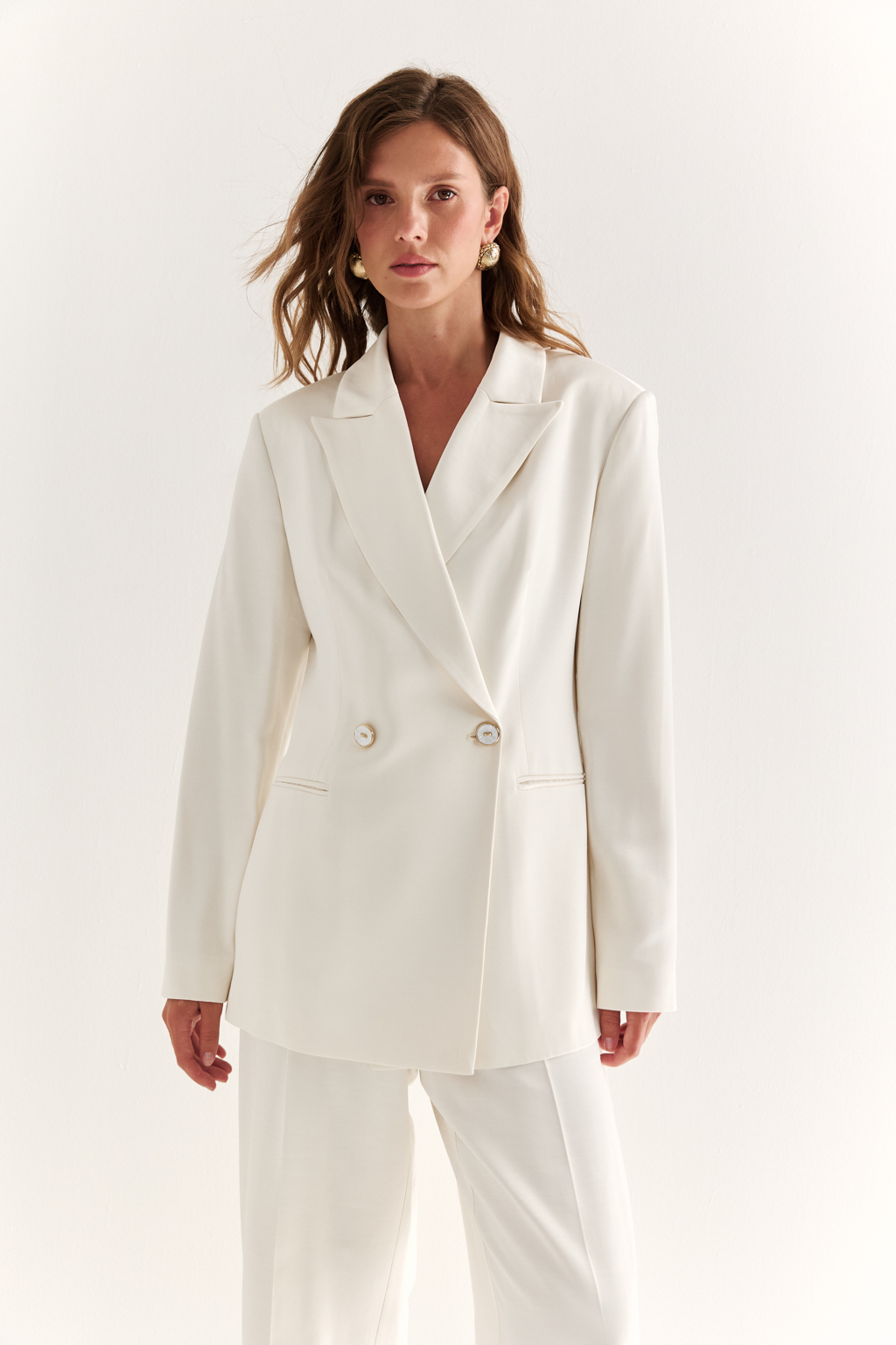 Двубортный жакет: классика в современной геометрии. Удлинённый двубортный жакет — это база, которая говорит о статусе без слов. Чёткие плечи, графичный крой и острые лацканы формируют уверенный, собранный образ. Рельефы по спинке и бокам подчёркивают силуэт, обеспечивая идеальную посадку, а карманы добавляют практичности и сдержанного акцента. Идеален в паре с классическими брюками, юбкой-карандашом или джинсами. Работает как в деловом комплекте, так и в вечерней стилизации. Современная структура с уважением к традиции.