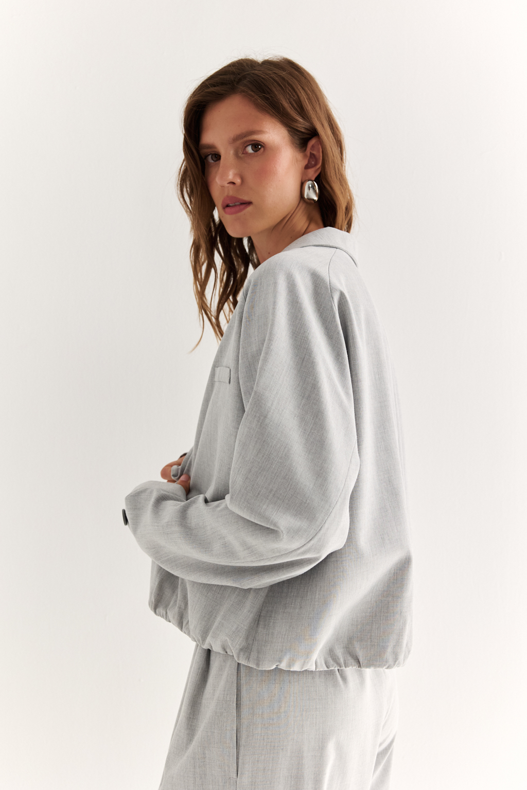 Укороченная рубашка-куртка: комфорт в ритме города. Свежий взгляд на casual-классику — рубашка-куртка силуэта баллон с акцентом на линии плеч и складками по низу изделия. Укороченная длина визуально вытягивает ноги и подчёркивает талию, а свободный рукав-реглан придаёт образу расслабленность и лёгкую дерзость. Застёжка на пуговицы, карманы листочки и воротник в мужском стиле добавляют характер, а функциональные детали обеспечивают удобство на каждый день. Сочетается как с джинсами и кроссовками, так и с юбкой-карандаш и каблуками — для игры на контрастах. Идеальный выбор для тех, кто ценит стиль и свободу движения.