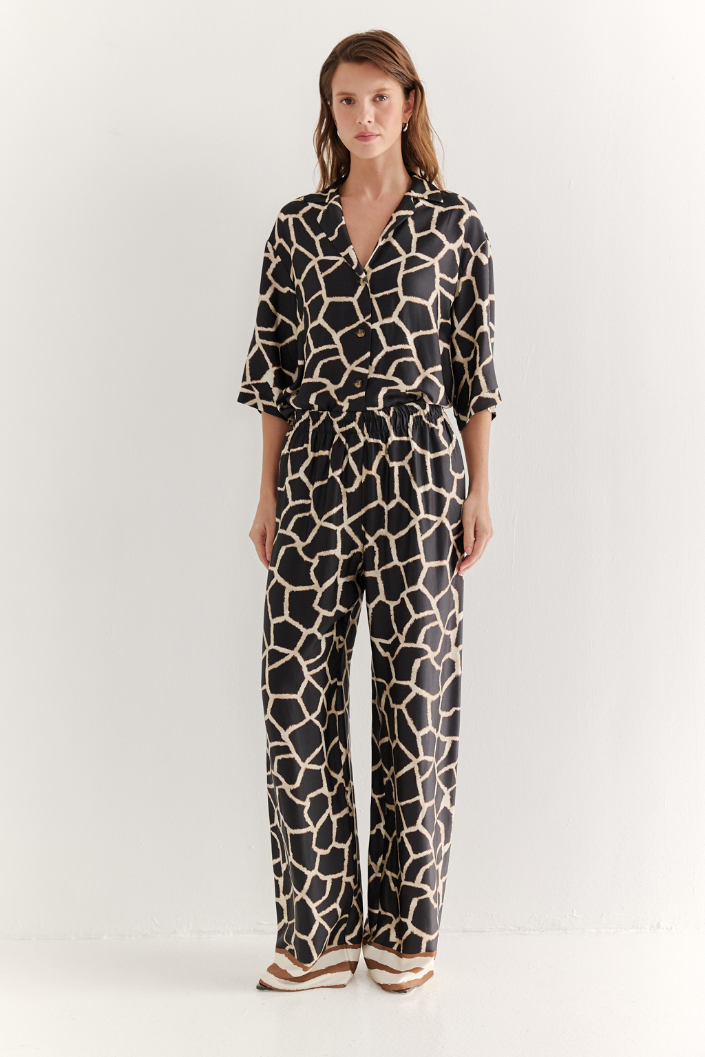 Брюки, широкие и прямые по всей длине, выполнены из полированной вискозы с шелковистой текстурой, украшена эксклюзивным анималистическим принтом, разработанным дизайнерами бренда. Основной тренд - создание атмосферы комфорта, пронизанной заботой и бережным отношением к себе. Брюки оснащены удобными карманами и эластичным поясом, обеспечивающими максимальный комфорт и удобство. По низу брюк – контрастный по цвету бордюр. Идеальным дополнением к этим брюкам станут блуза из той же коллекции, а так же объёмный трикотажный кардиган.