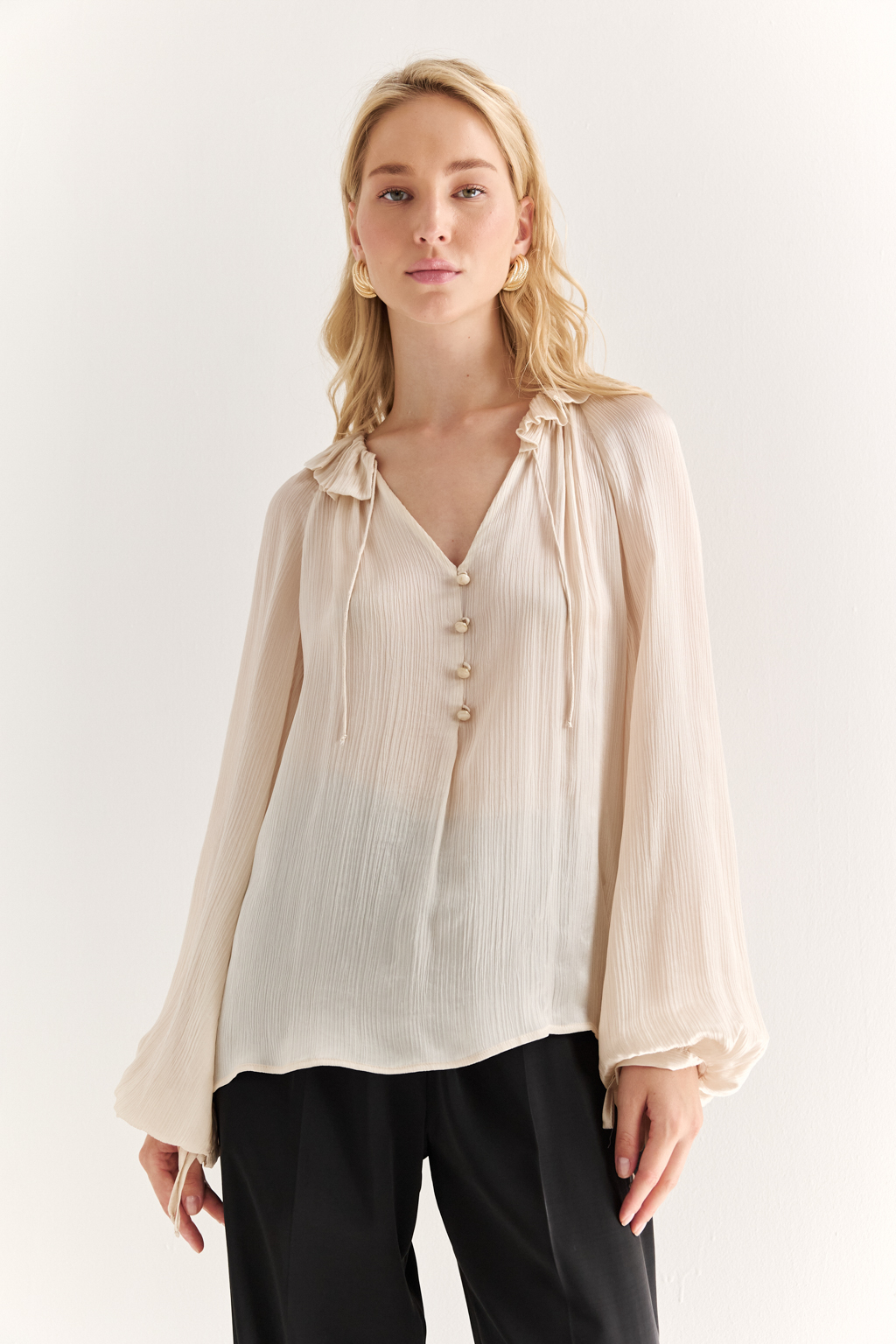Блуза из 100% шёлка: воздушная элегантность с характером. Эта блуза создана из натурального шёлка — благородной ткани, которая буквально скользит по коже и придаёт образу утончённость. Объёмные рукава с  завязками создают лёгкий силуэт, а мягкая рюша по линии горловины добавляет динамики и изящества. Прямой крой обеспечивает комфорт и универсальность: блуза легко адаптируется под офисный стиль, романтичные образы или вечерние выходы. Носите с классическими брюками, юбками или джинсами — она всегда выглядит достойно. Чистый шёлк. Чистая элегантность.