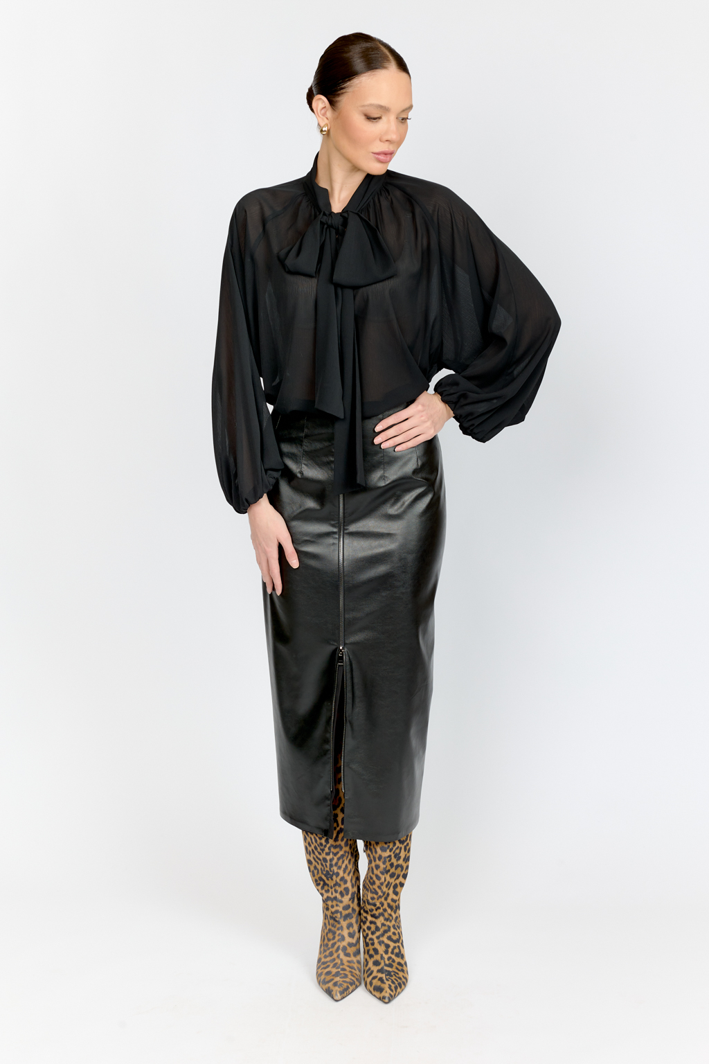 Юбка прямого кроя полуприлегающего силуэта с акцентной застежкой на металлическую молнию спереди из черной экокожи .