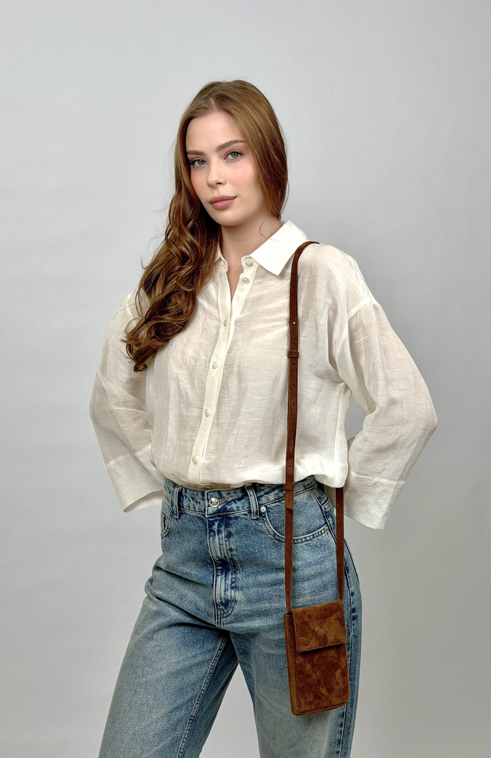 Стильный аксессуар из натуральной замши надёжно защитит Ваш гаджет от ударов и других внешних воздействий. Оснащена основным отделением для смартфона и разнообразных мелочей, а также двумя карманами для банковских карт и визиток. Сумка имеет регулируемый ремешок. Размеры: 17,5*10,3 см